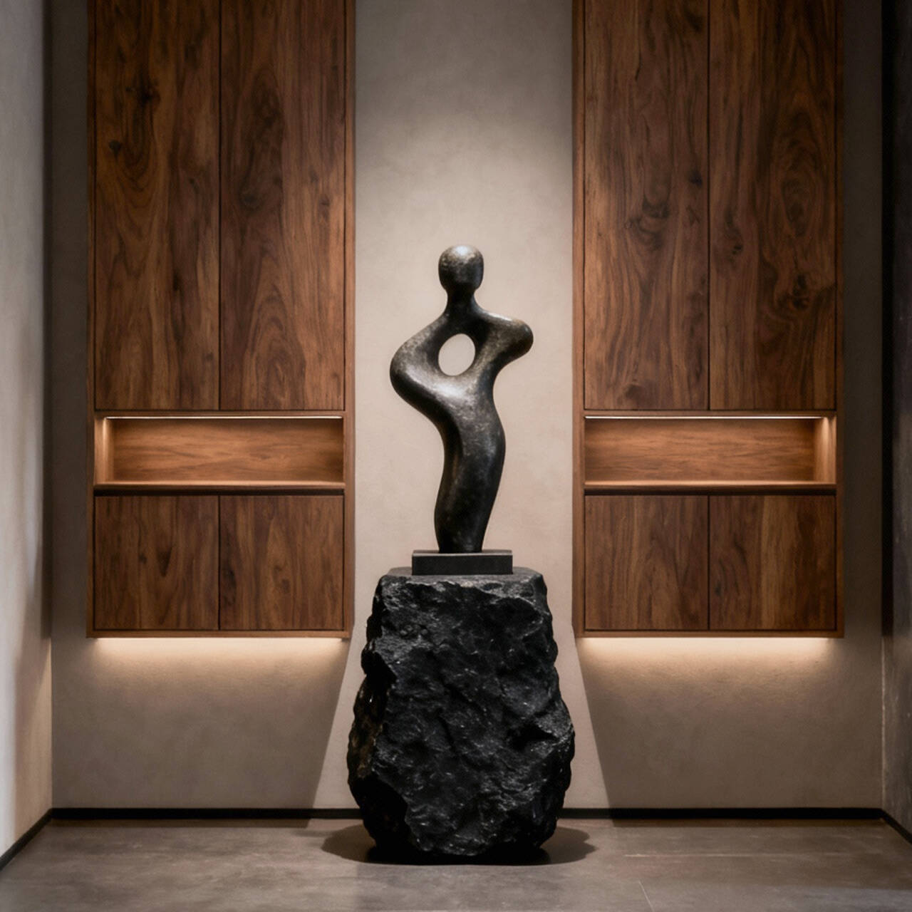 Black abstract sculpture on a rock pedestal in a modern interior setting with wooden panels.