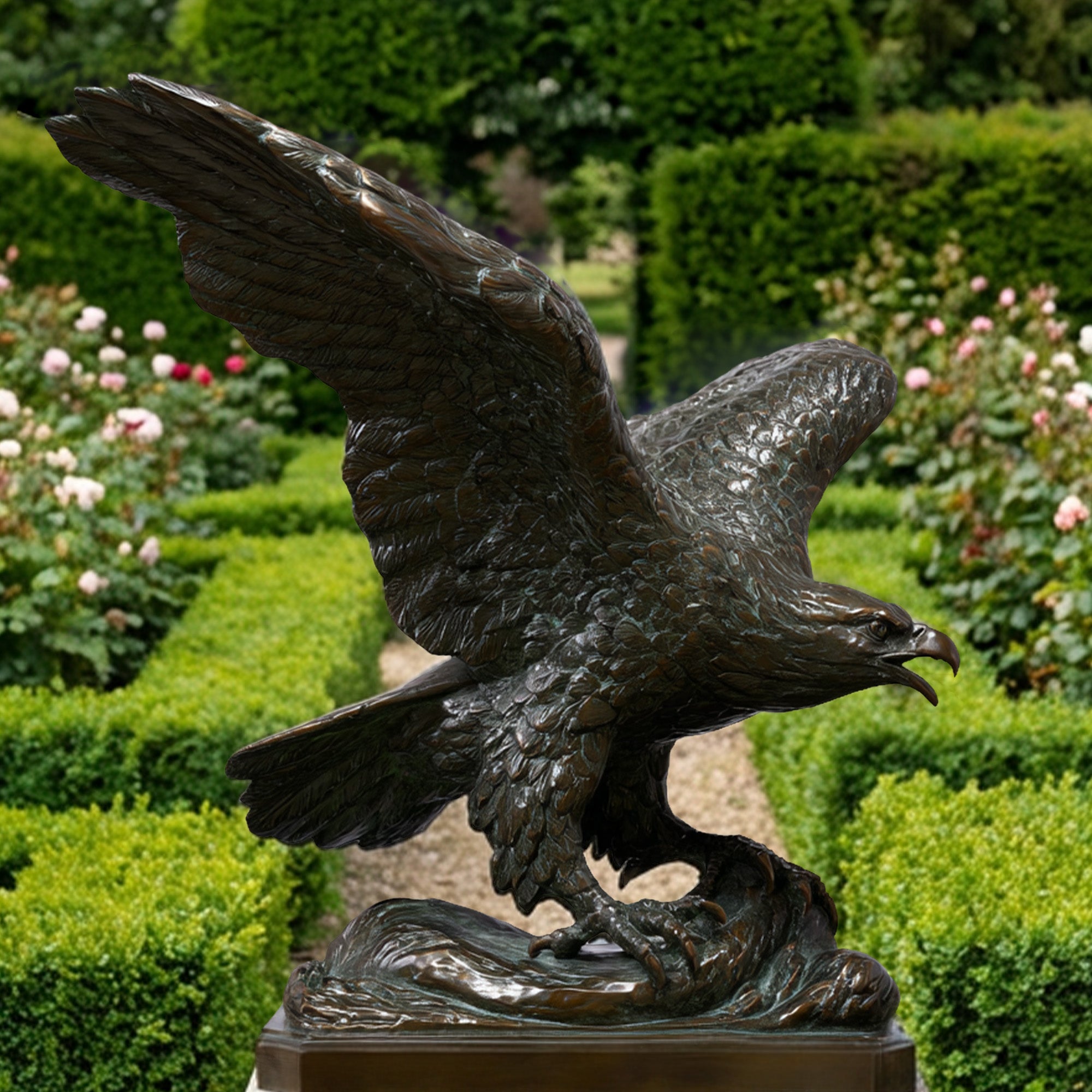 Bronze eagle statue in a garden setting with greenery and flowers.