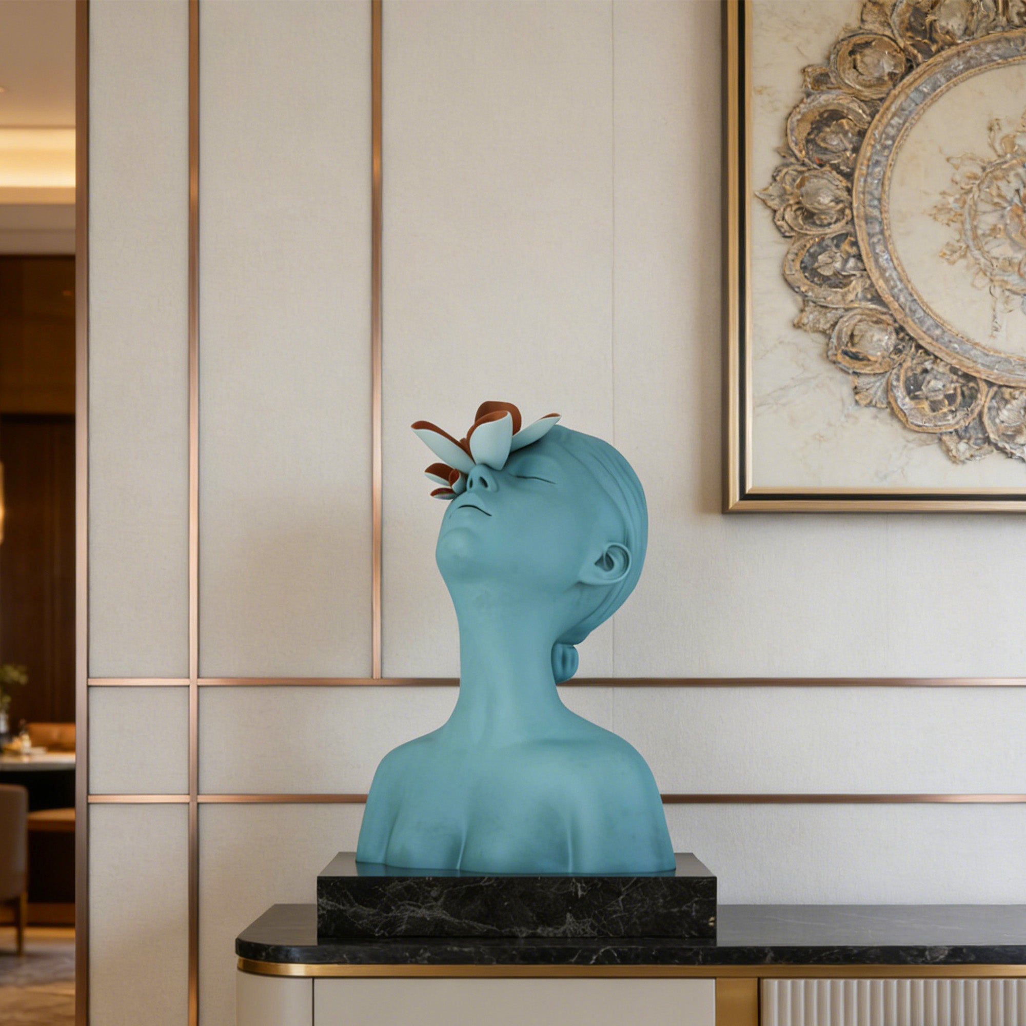 Blue decorative bust with a flower on a black marble base in an elegant interior setting.