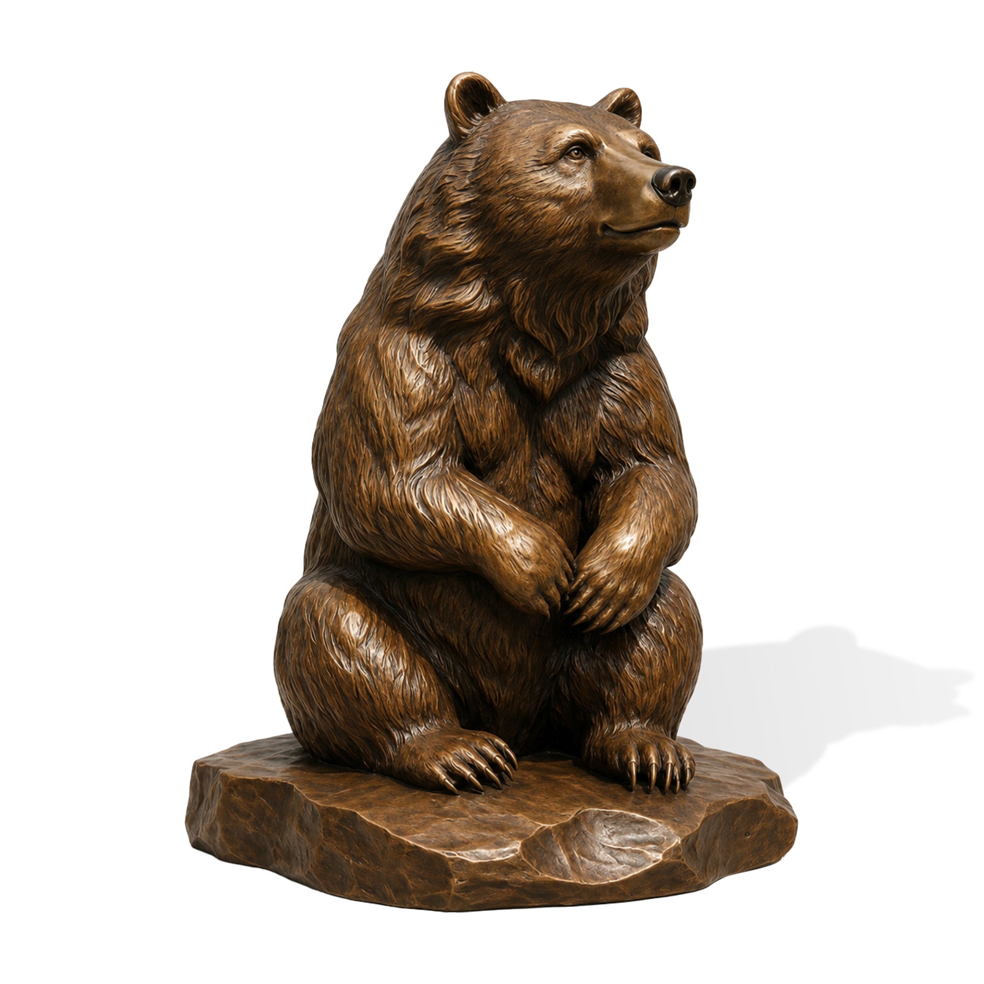 Front three-quarter view of a bronze sitting bear sculpture on a white background, featuring lifelike fur texture, calm expression, folded paws, and natural rocky base.