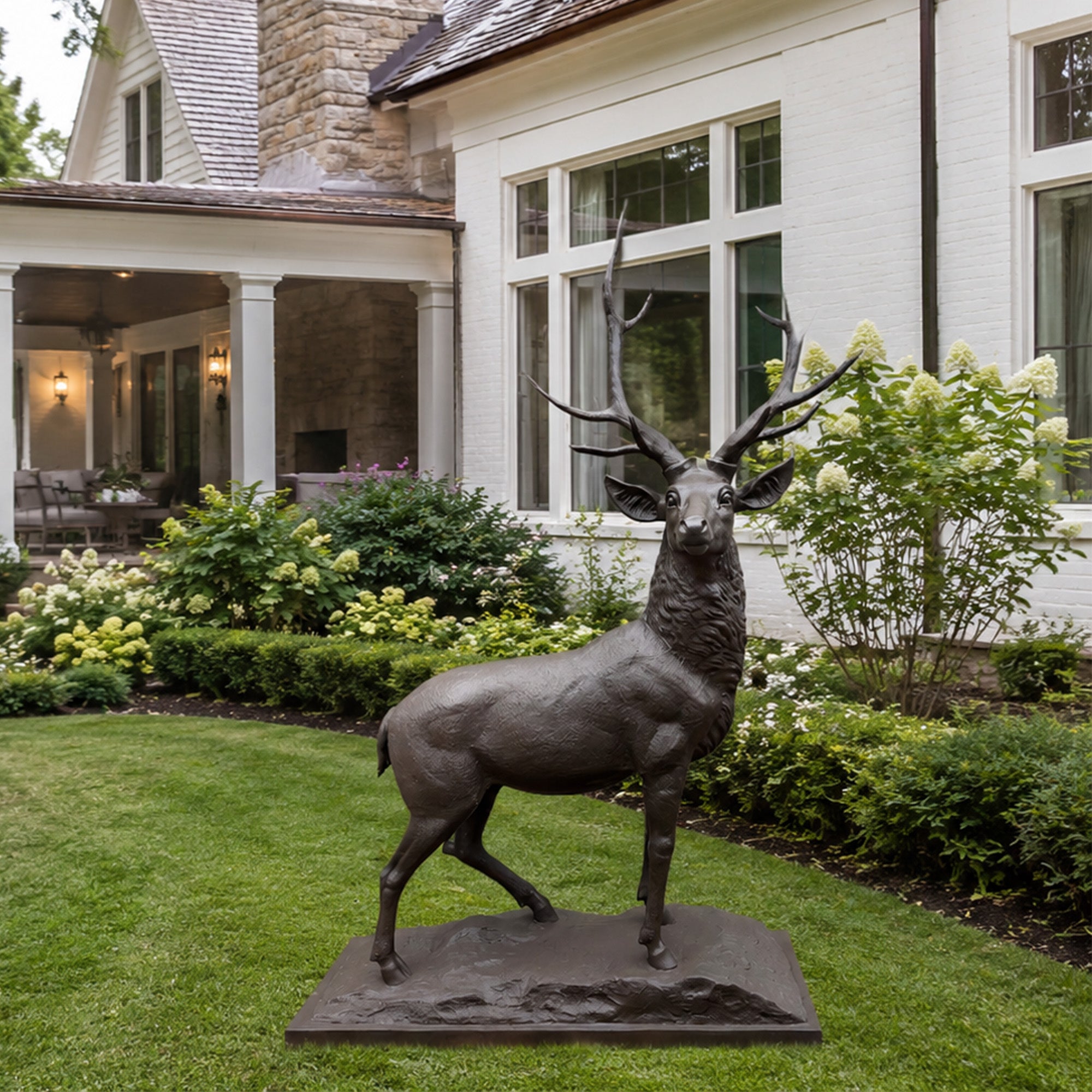 Bronze elk statue displayed in a private residential garden, surrounded by lawn, shrubs, and flowers as an elegant courtyard landscape decoration