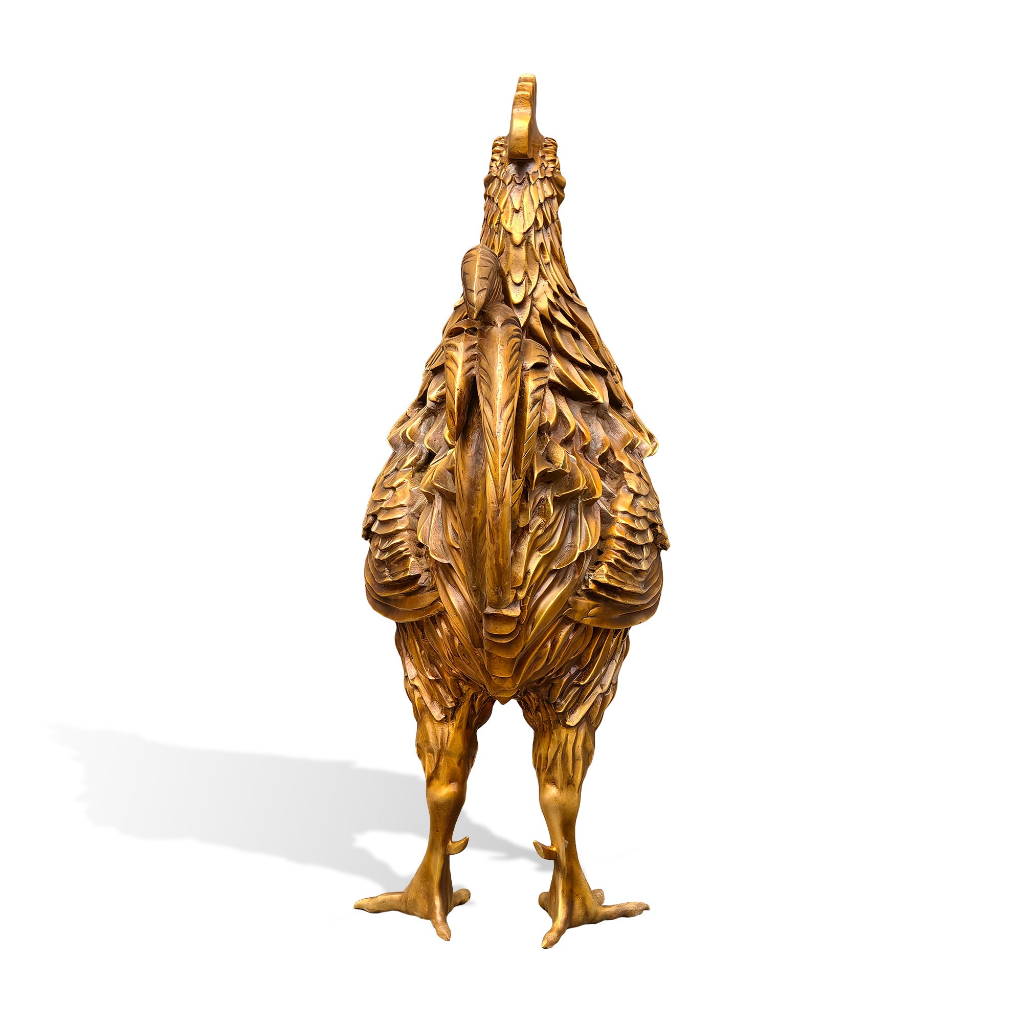 Rear three-quarter view of a golden bronze zodiac rooster statue showing layered back feathers, sweeping tail plumes, sculpted wing texture, and upright standing pose on a white background.