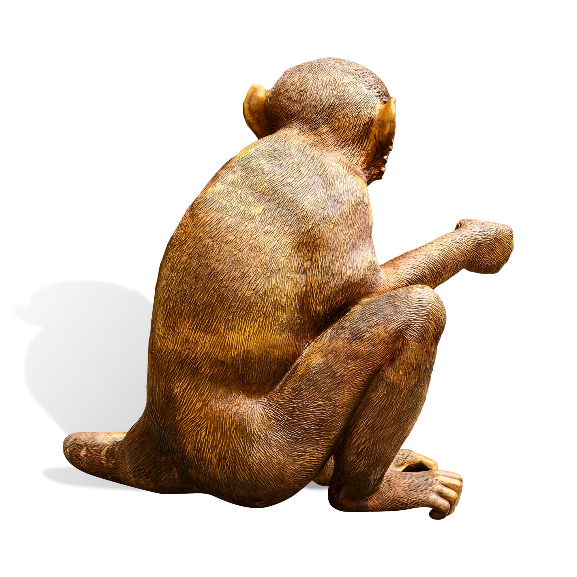 Rear view of a golden bronze zodiac monkey sculpture with seated posture, textured fur, curved tail, bent legs, and detailed ears on a white background.