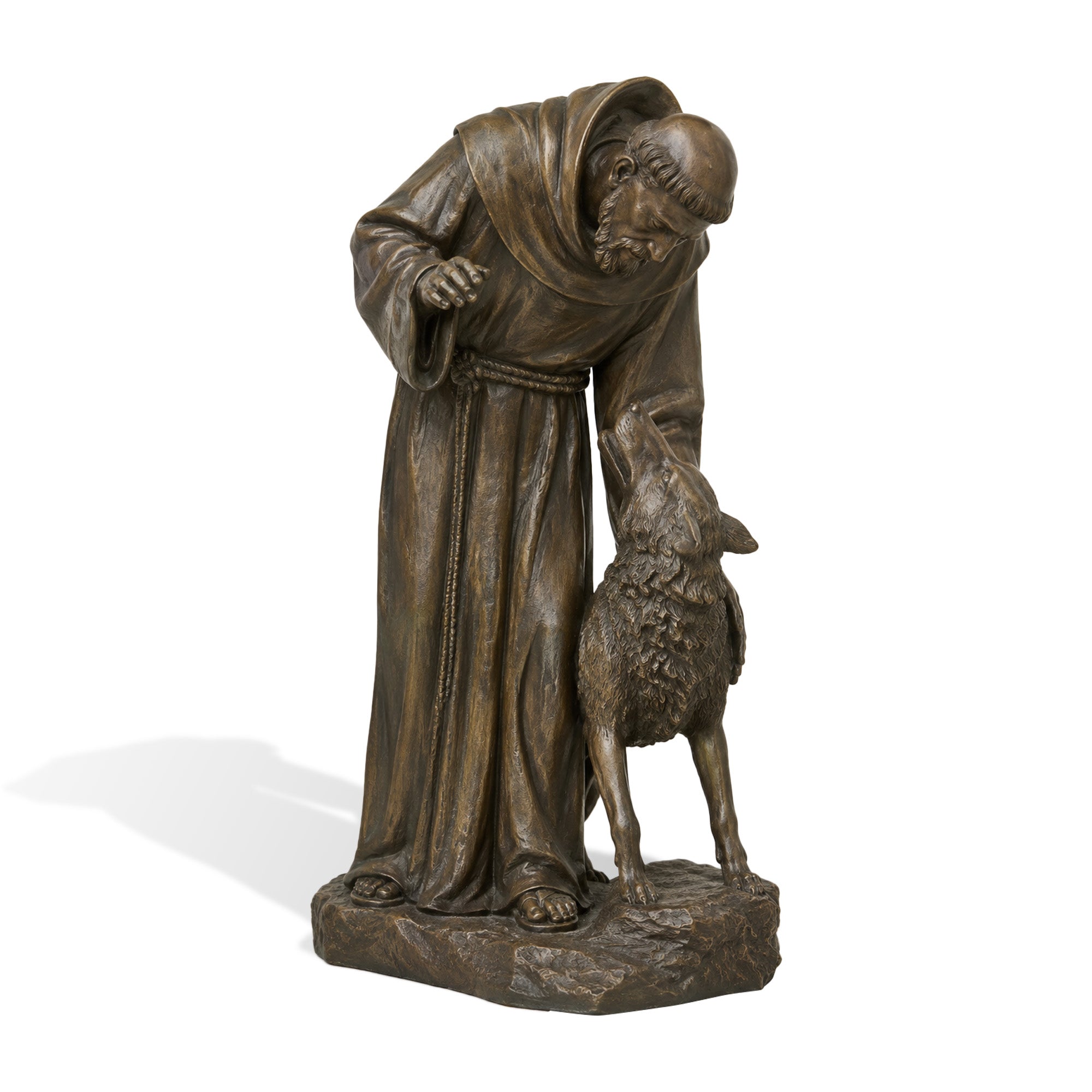Front view of a bronze Saint Francis religious sculpture with a robed monk figure bending toward a wolf, detailed robe folds, rope belt, and natural stone-style base on a white background.