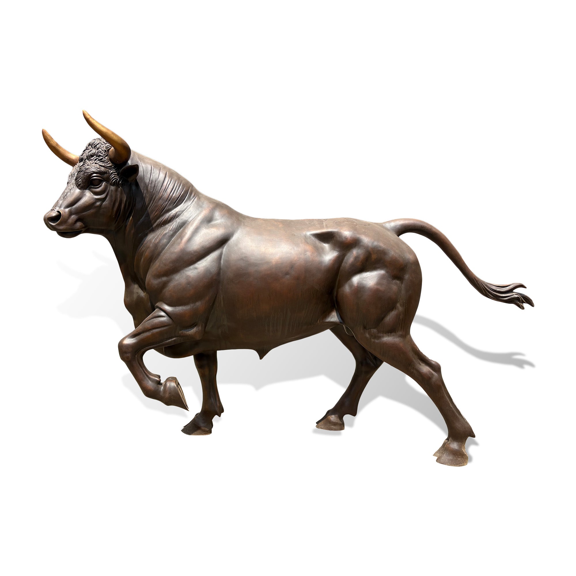 Bronze bull sculpture in dynamic running pose with detailed horns, muscular body, and realistic handcrafted metal artwork