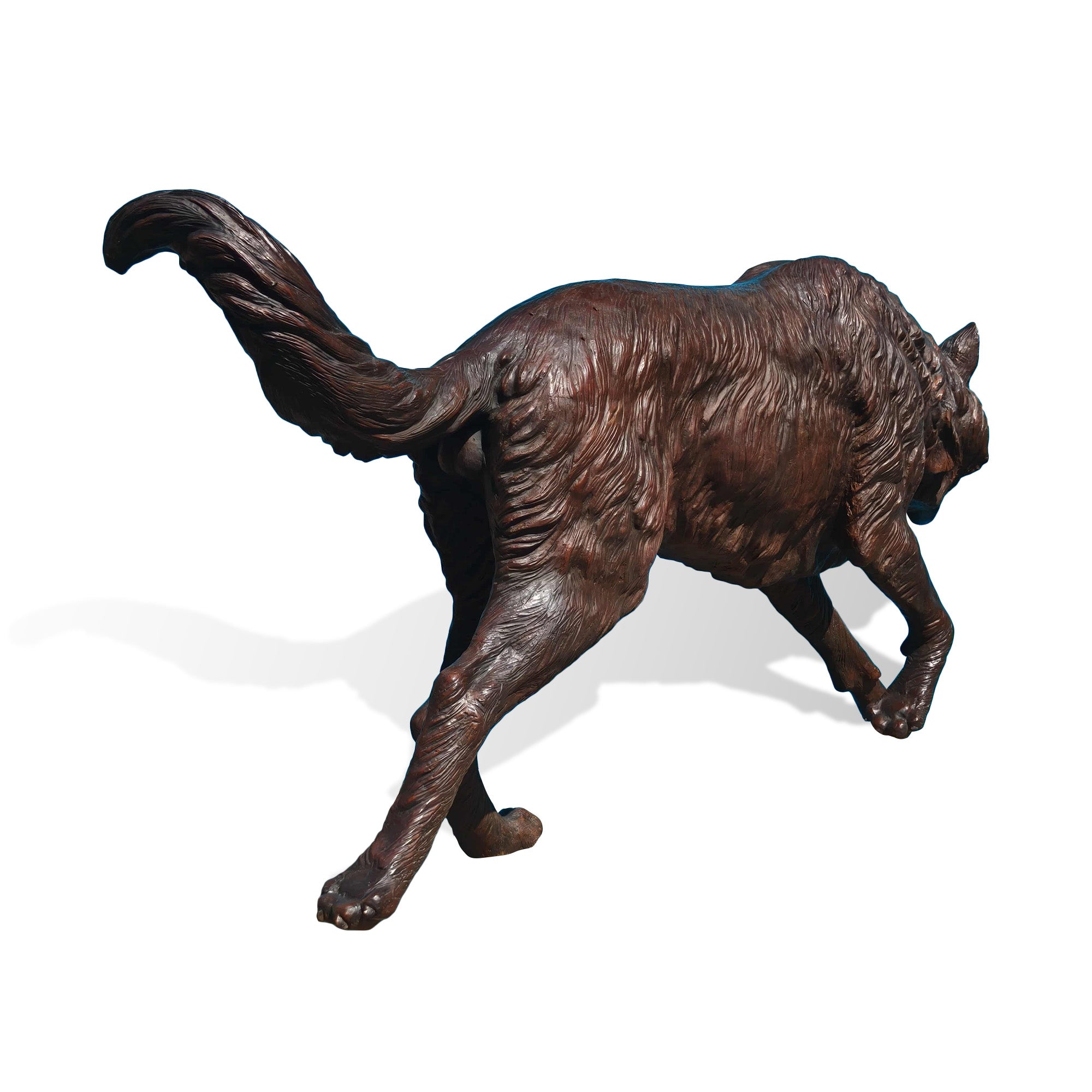 Back view of a realistic bronze wolf statue showing detailed carved fur, muscular body shape, raised tail, and fine craftsmanship of wildlife sculpture.