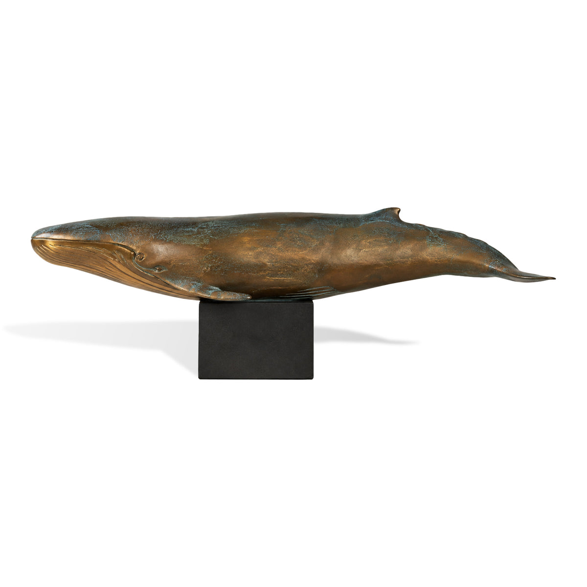 Bronze whale sculpture with blue green patina displayed on a minimalist black pedestal