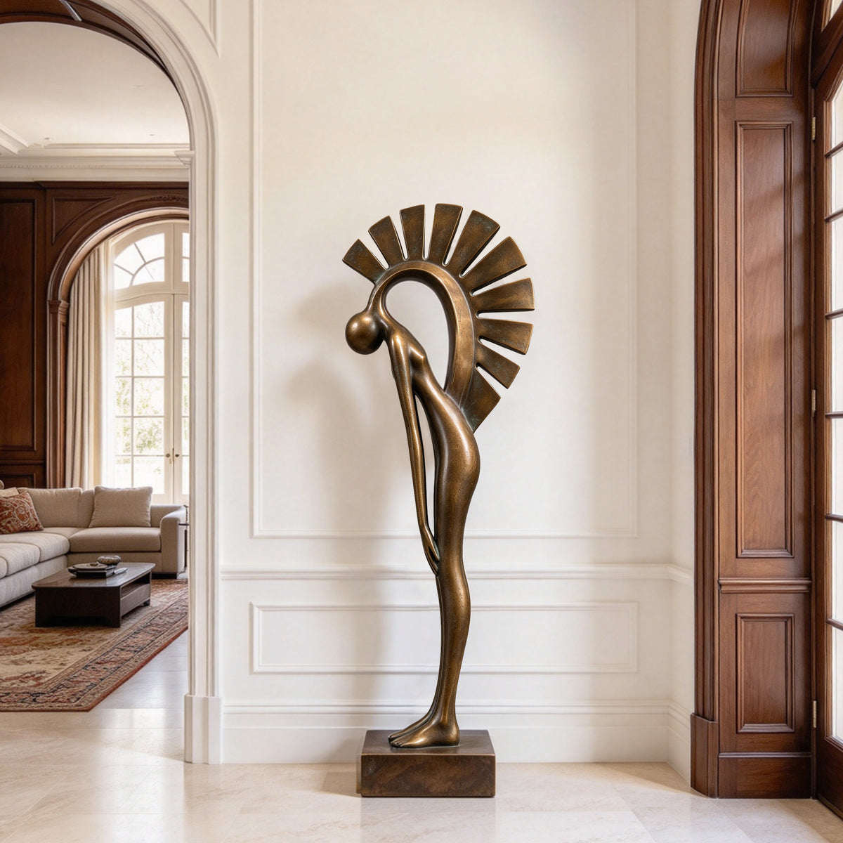 Tall abstract bronze human figure sculpture with a bowed head, elongated body, and radiating geometric halo, displayed on a rectangular base in an elegant luxury home interior.