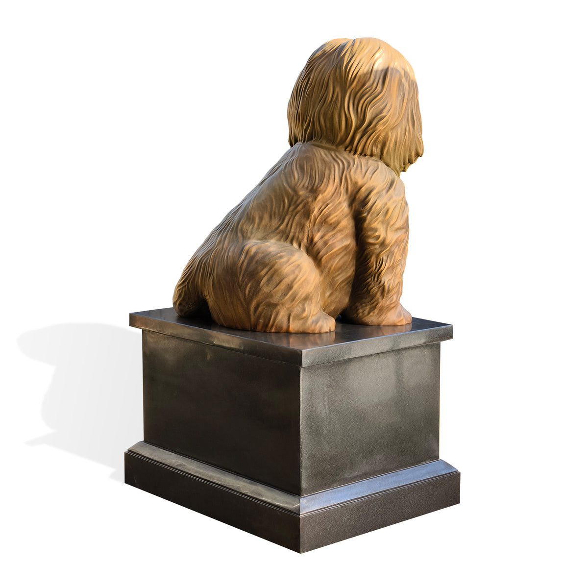 A sculptural dog statue shown from the back, seated on a dark rectangular pedestal against a clean white background.