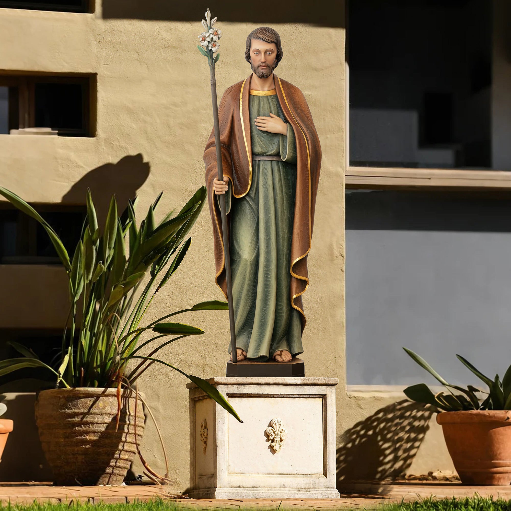 Hand-painted fiberglass sculpture of Saint Joseph holding a lily staff, wearing green and brown robes.