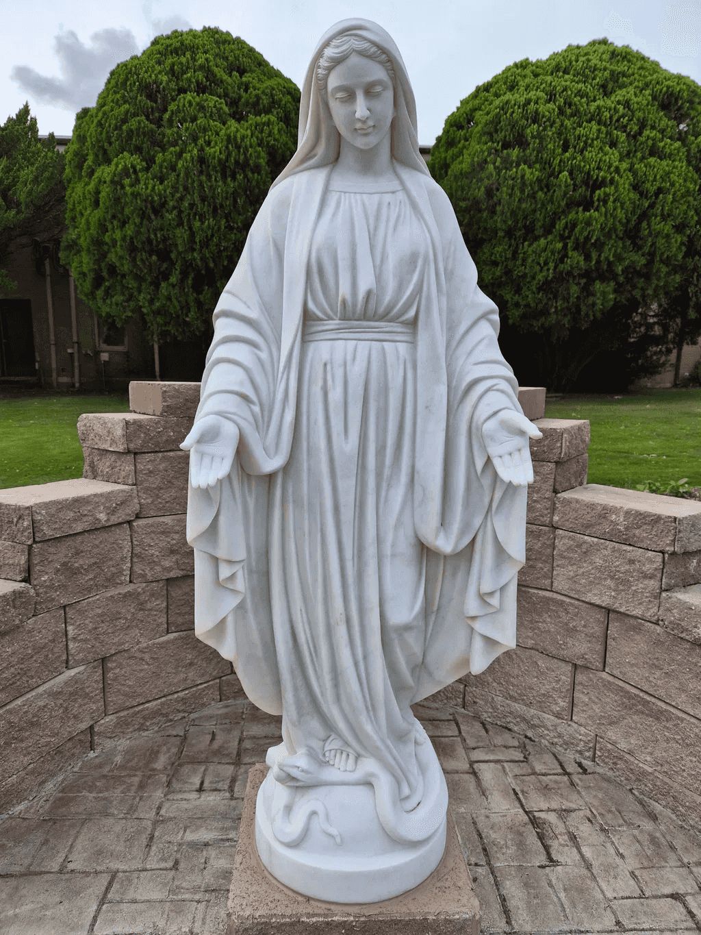 Detailed white marble Virgin Mary Catholic statue with open hands standing over a serpent