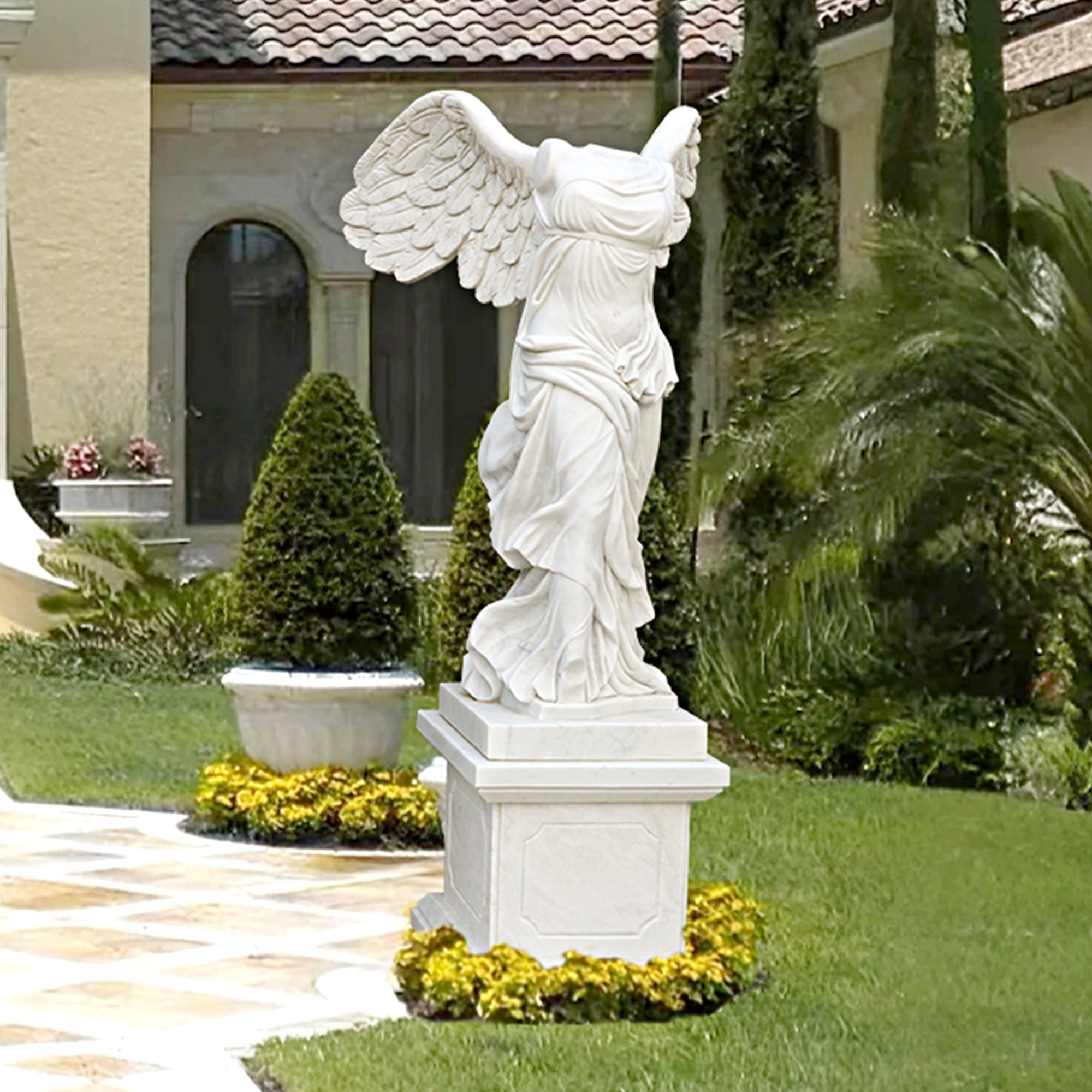 White marble Winged Victory of Samothrace statue with detailed wings and flowing drapery, displayed on a pedestal for indoor or outdoor use.