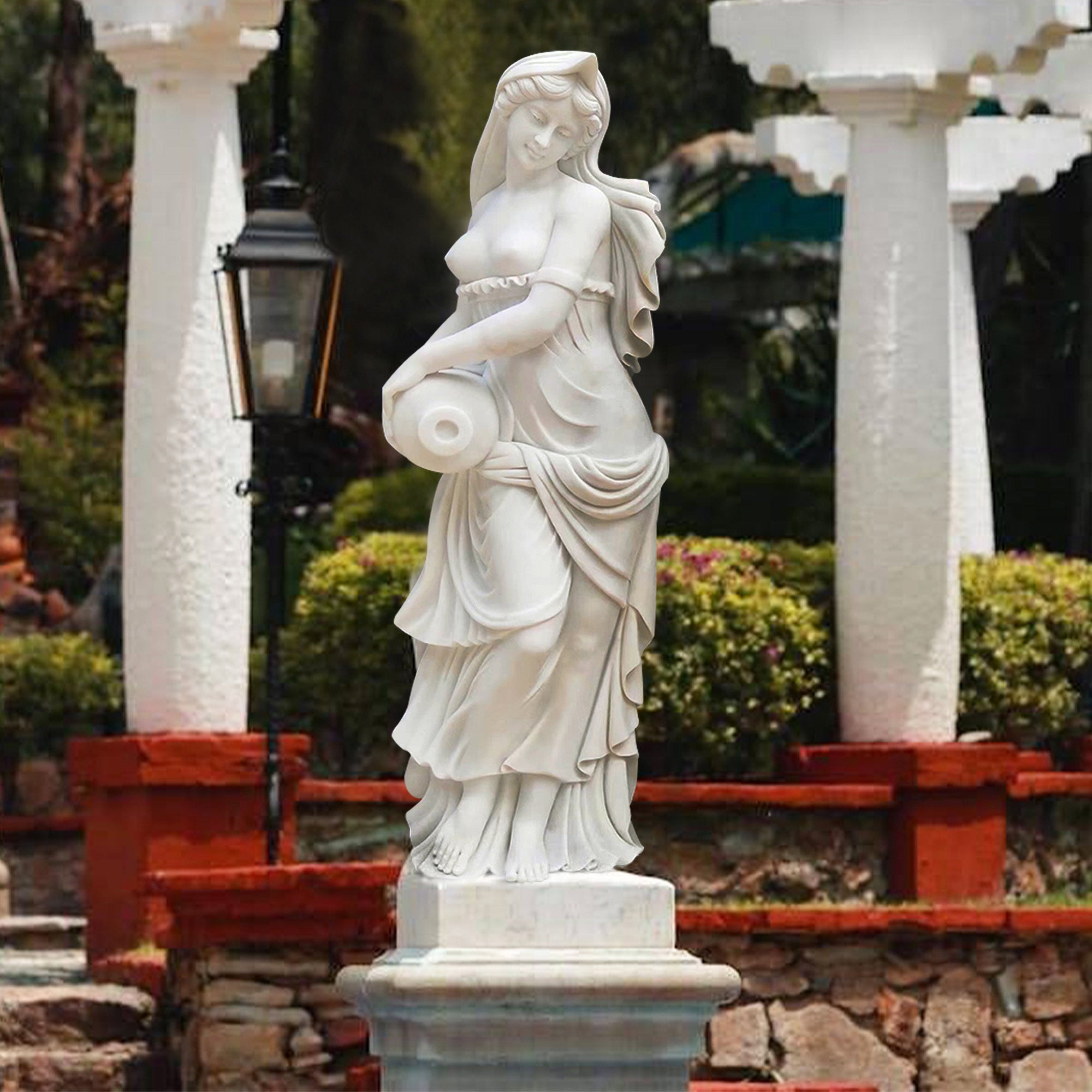 Marble statue of a Greek water maiden holding an amphora, with flowing robes, displayed in a garden setting.