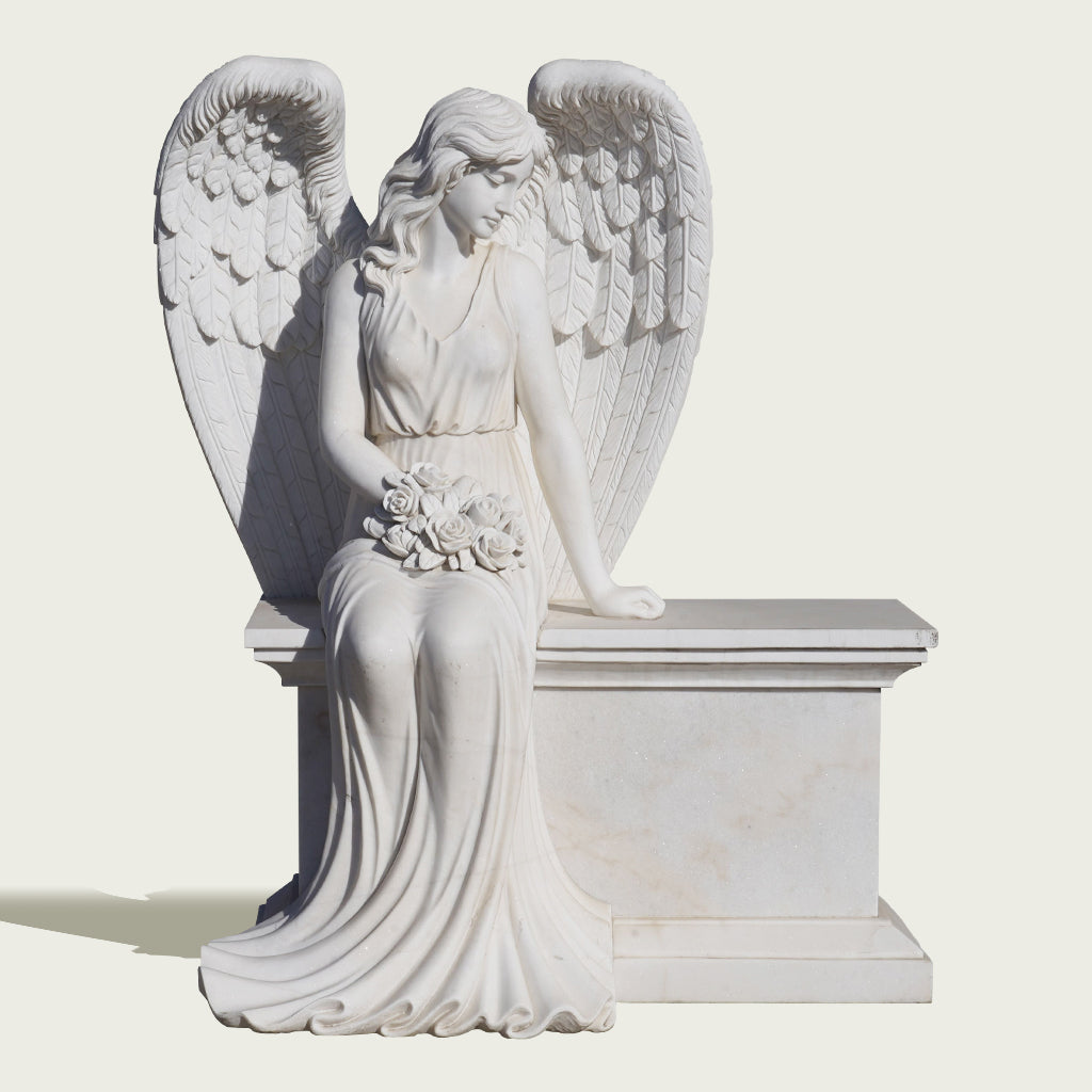 Stone angel statue seated on a bench holding roses