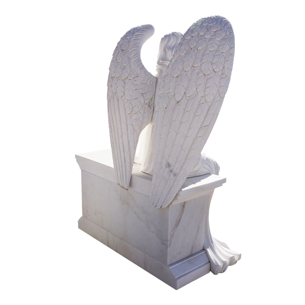 Stone angel statue seated on a bench holding roses