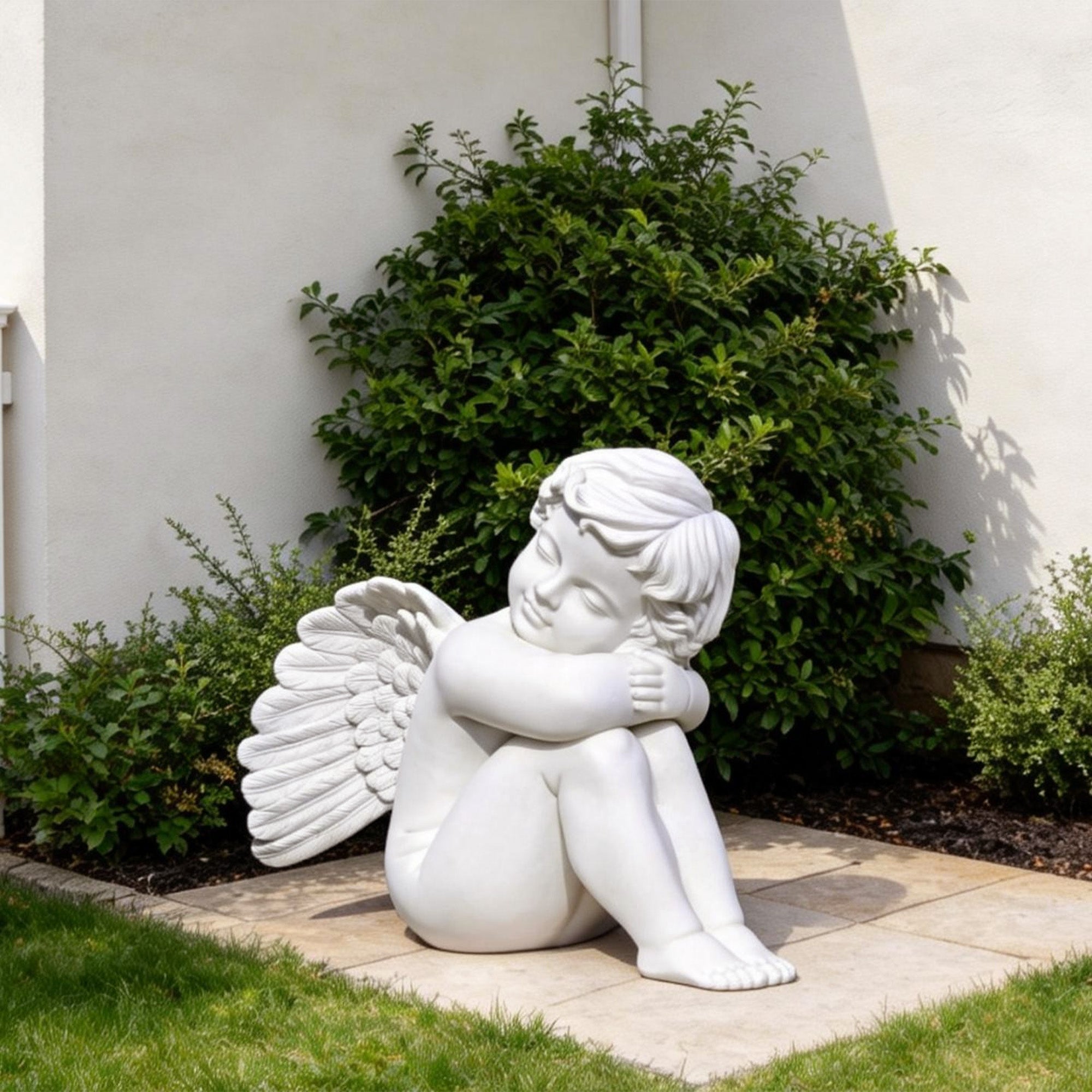 Delicate white marble cherub sculpture with wings, resting peacefully, perfect for enhancing the charm of garden or patio areas.