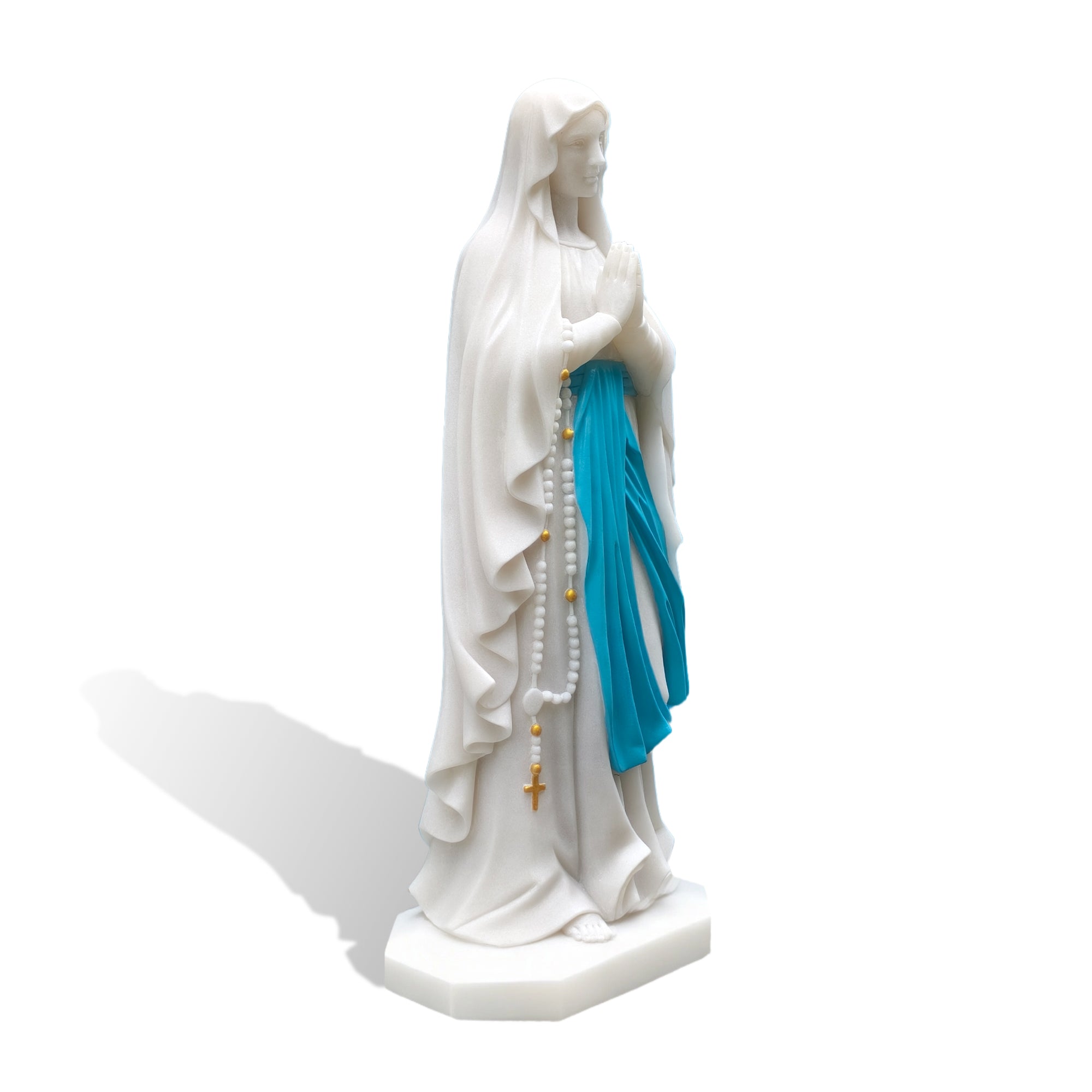 Profile view of white marble Virgin Mary sculpture on plain backdrop