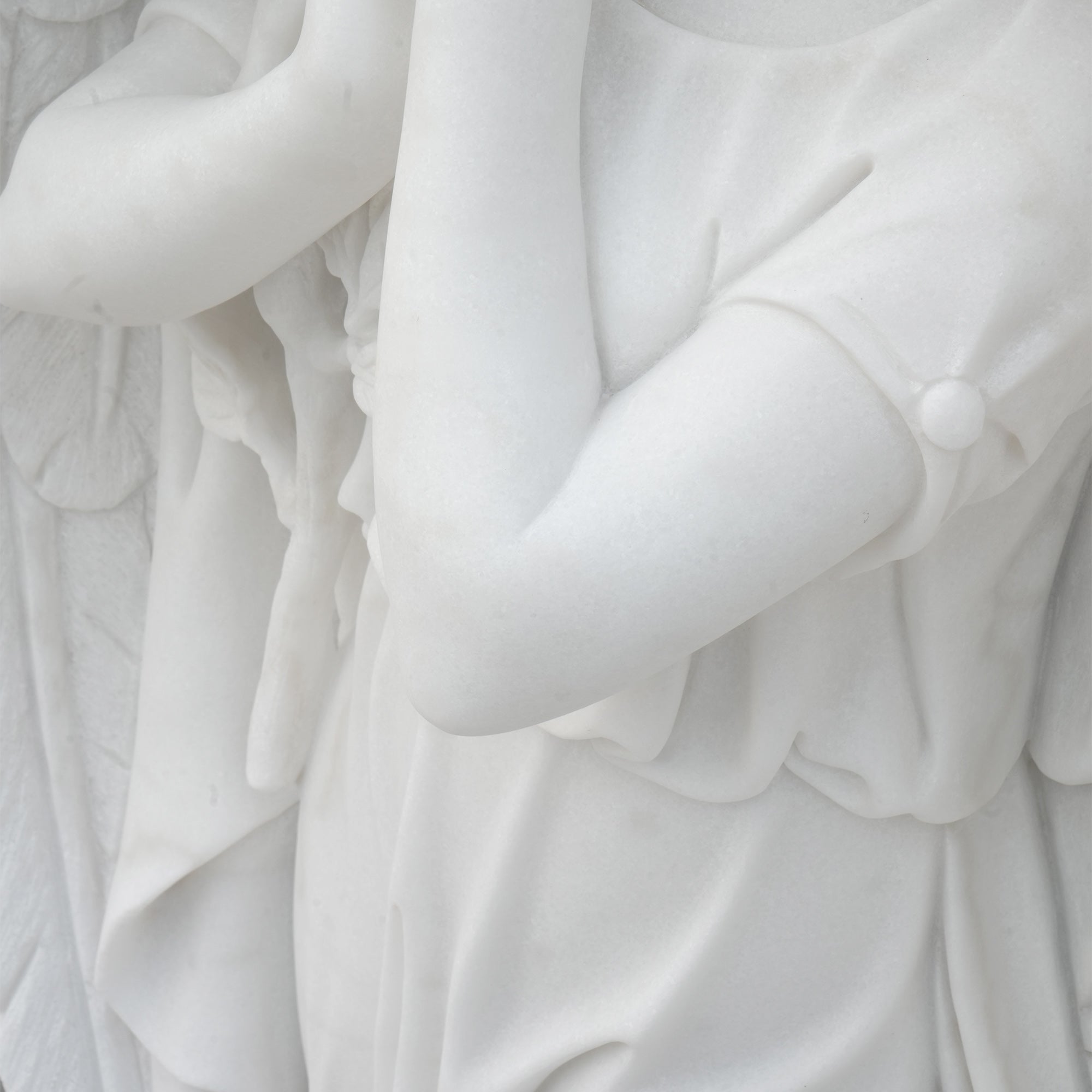 angel memorial marble sculpture arm detail showing smooth carving and robe folds