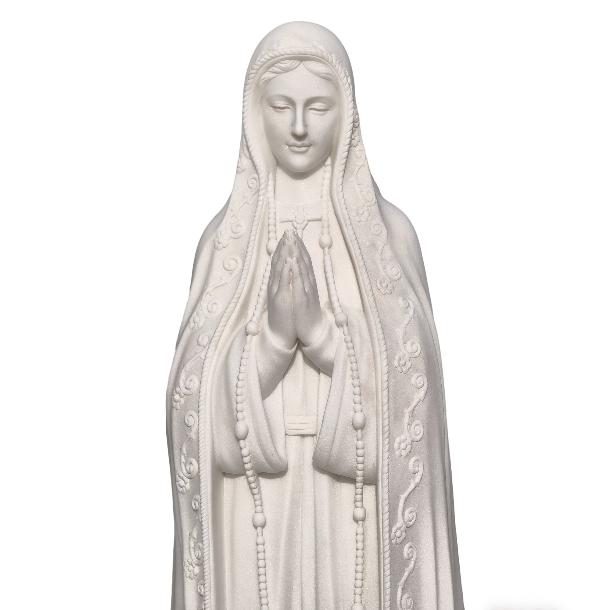 Close-up of Our Lady of Fatima marble statue focusing on praying hands and facial expression, handcrafted religious artwork for devotional interiors and sacred spaces.