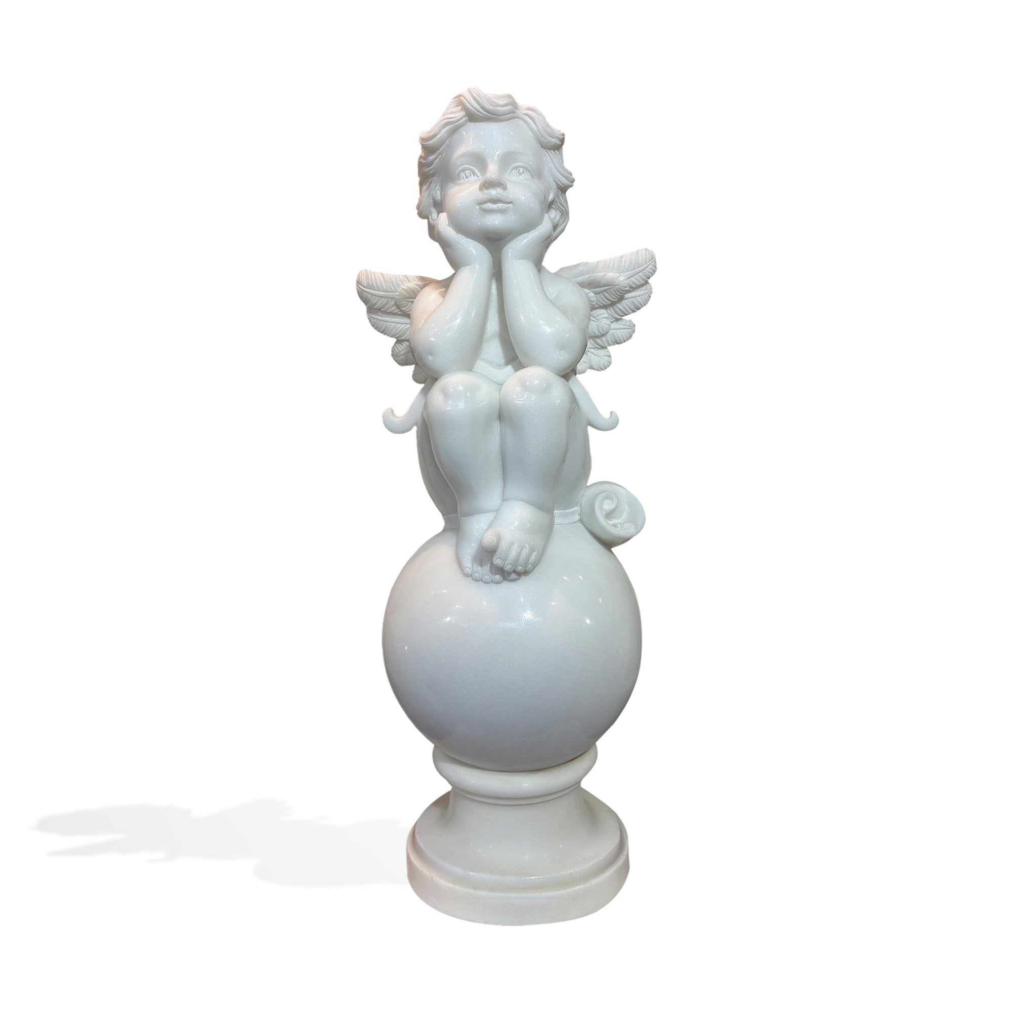 Front view of a white marble cherub statue sitting on a rounded sphere above a pedestal base