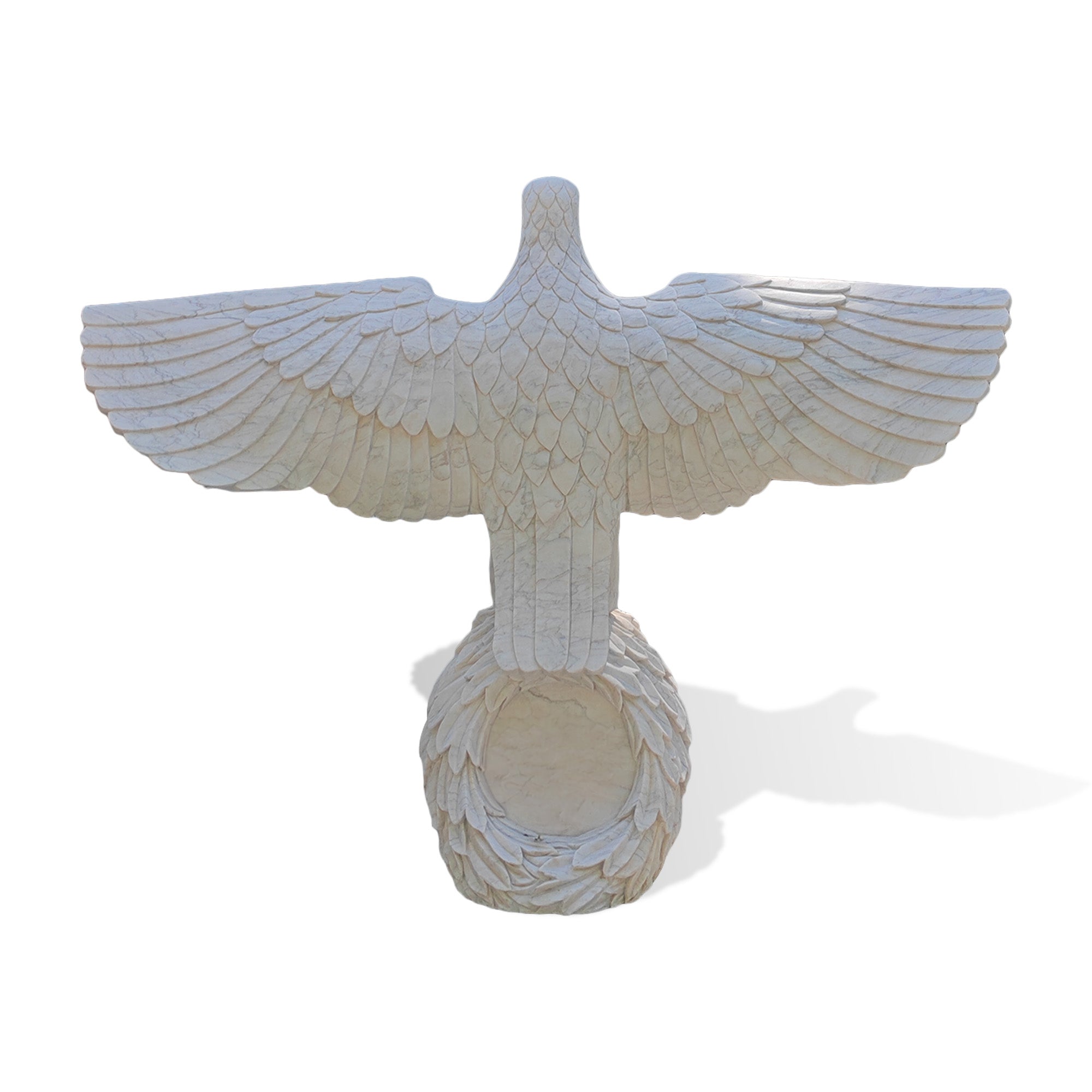 Rear view of a white marble eagle statue with fully spread wings standing on a carved globe base