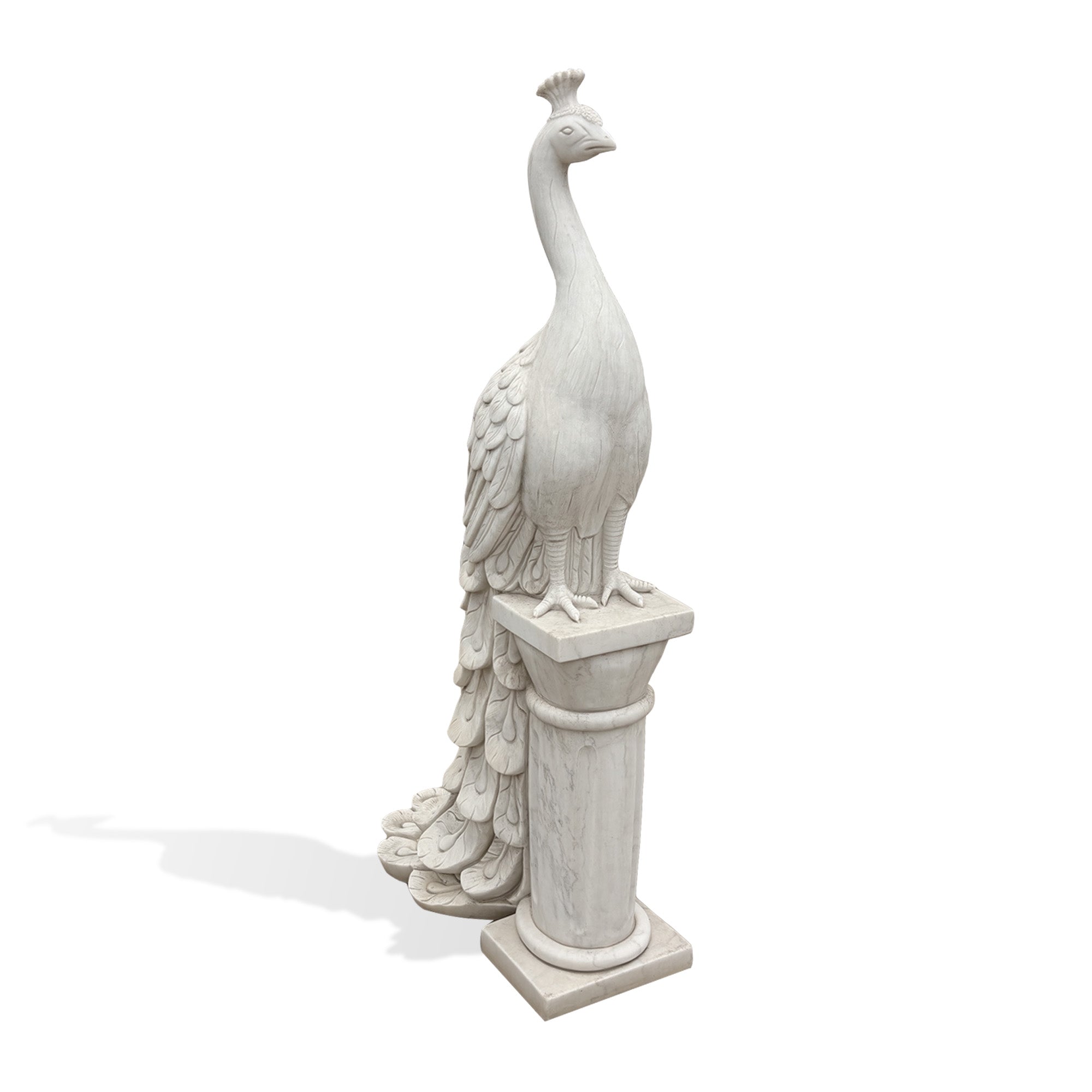 Front angle view of a hand-carved white marble peacock statue with a long flowing tail standing on a classical column pedestal