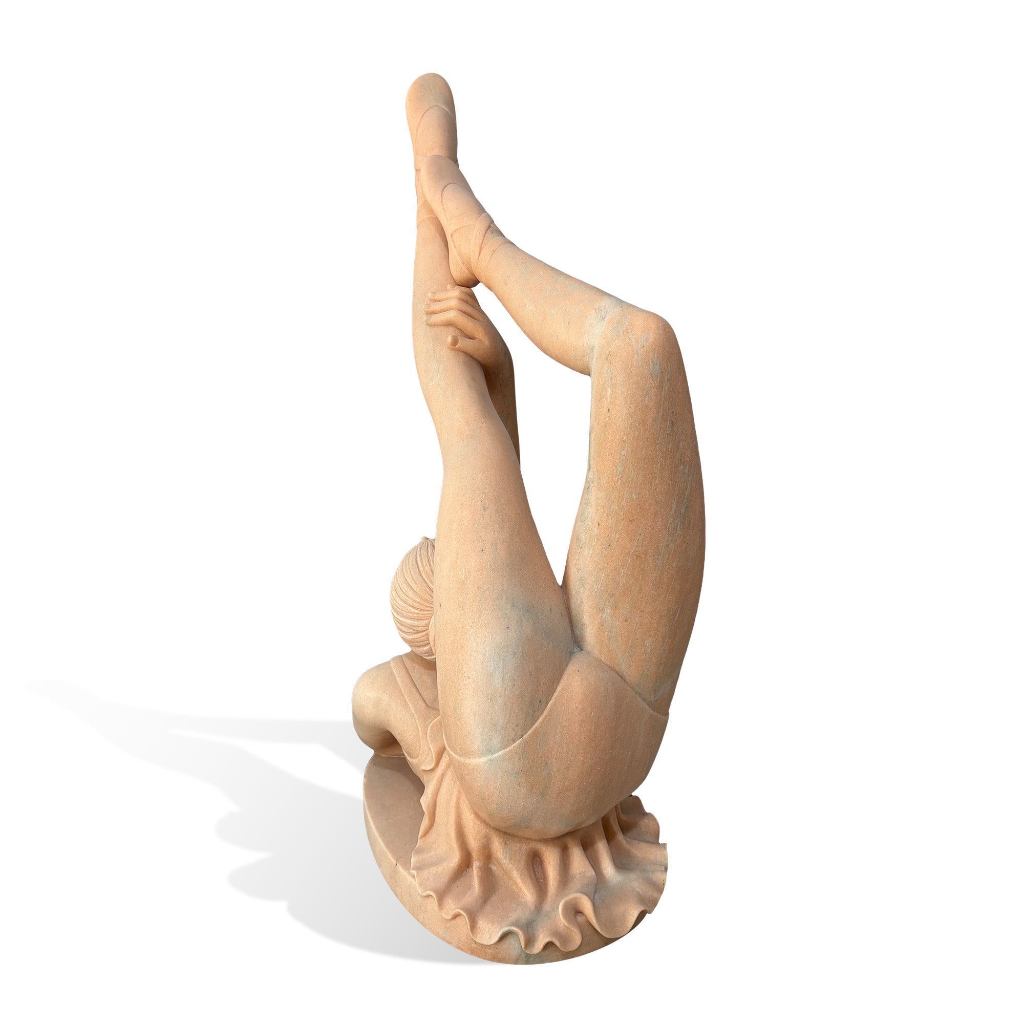 Back view of a natural stone ballet dancer sculpture with lifted legs, delicate hand placement, carved skirt movement, and a circular base