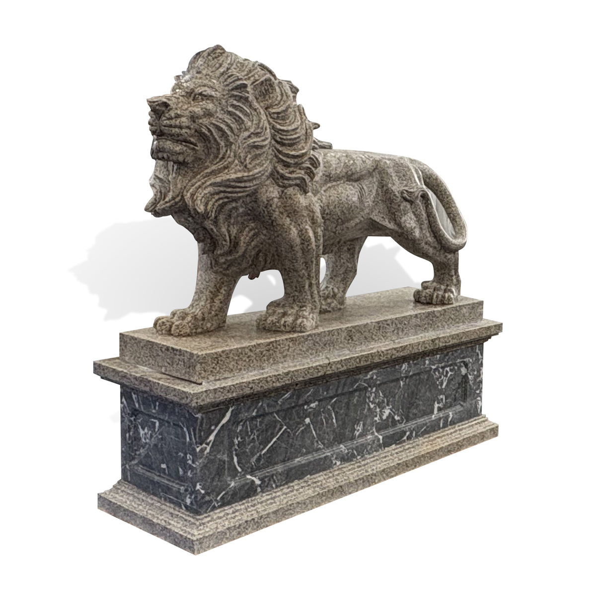 Side profile of a carved stone lion statue with a closed mouth, flowing mane, curled tail and decorative rectangular stone pedestal.