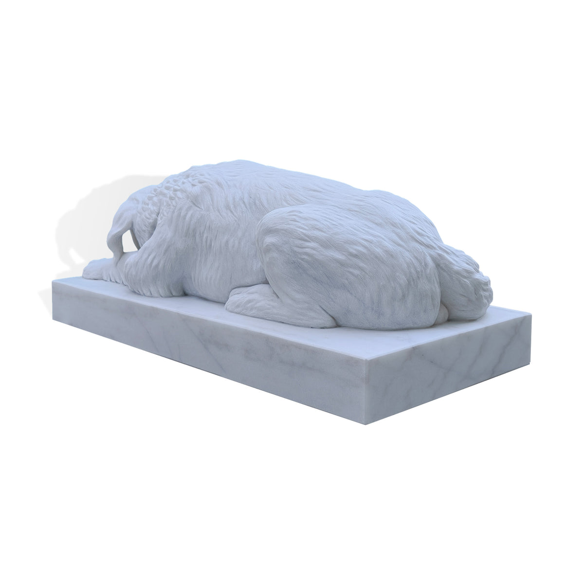 Rear three-quarter view of a reclining marble dog sculpture, highlighting carved fur across the back, folded hind legs and a thick tail curled alongside the body, supported by a rectangular white marble base.