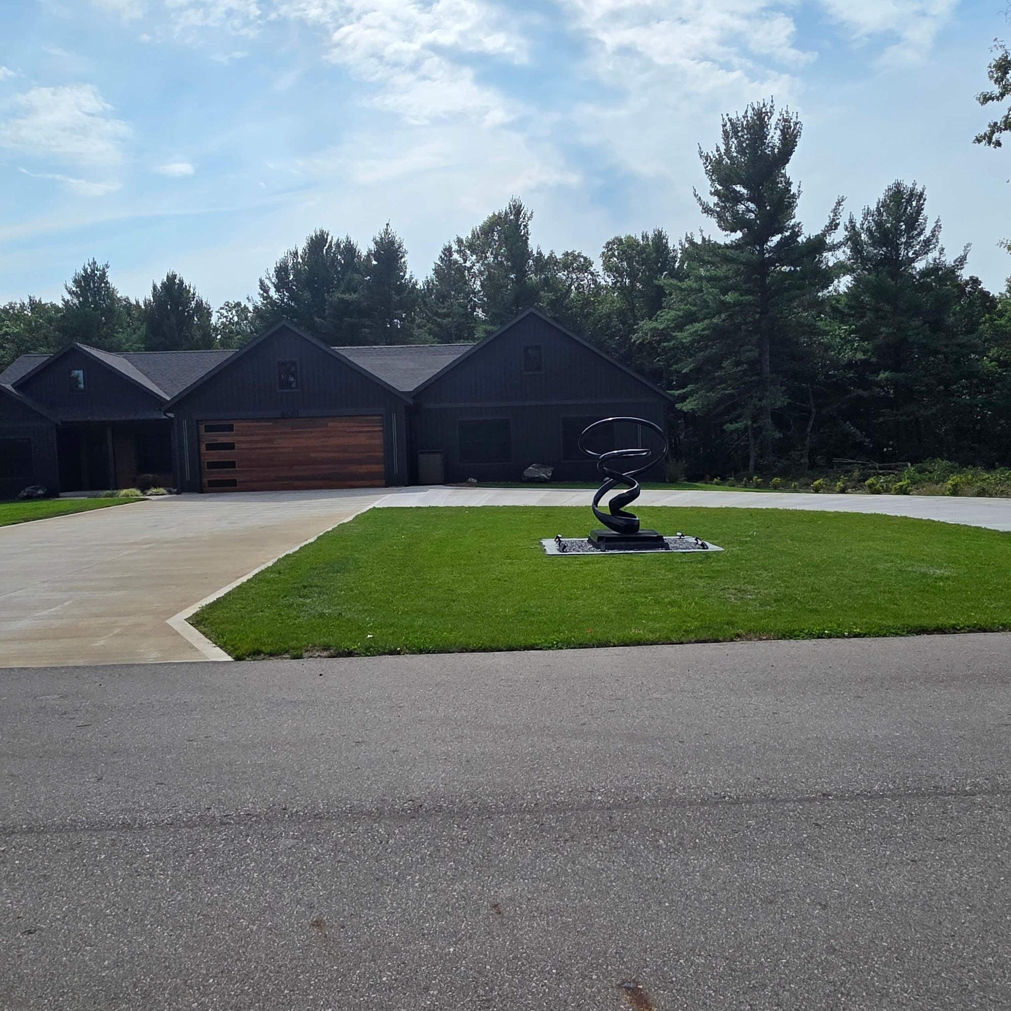 modern abstract outdoor painted stainles ssteel sculpture installed in front yard of residential home savannah way muskegon michigan daytime view