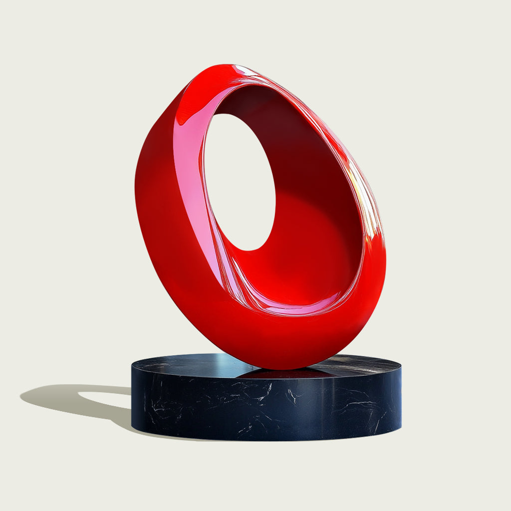 Red abstract stainless steel loop sculpture on a black marble base, with a high-gloss finish and contemporary design.