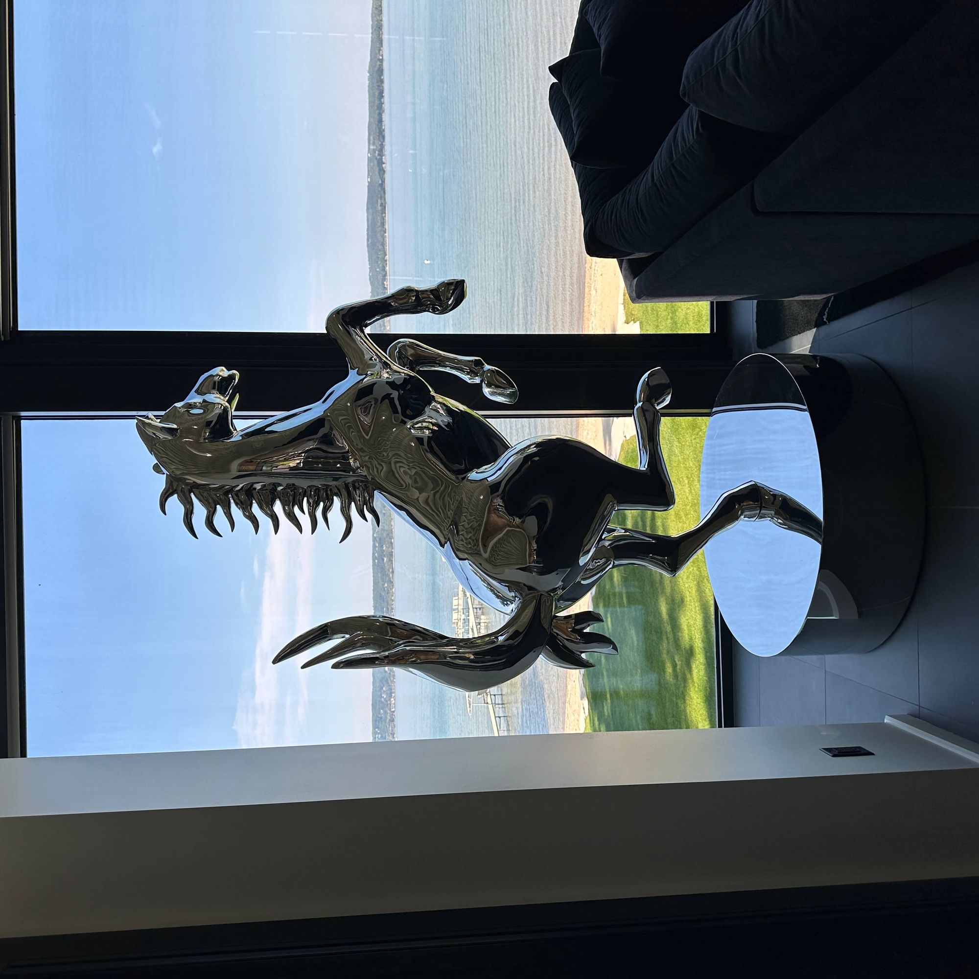 contemporary electroplated metal horse statue near window with ocean view