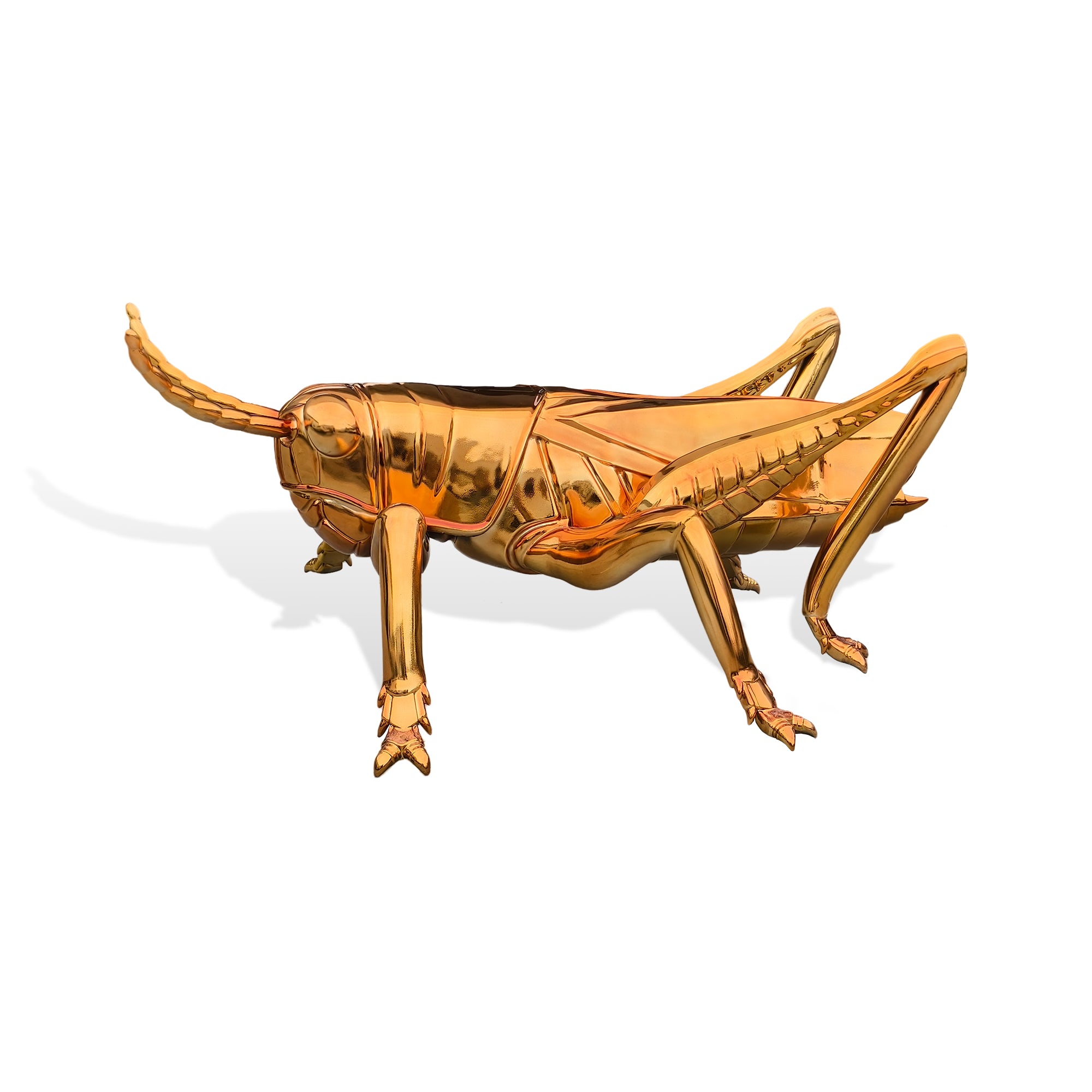 Gold grasshopper sculpture on a white background