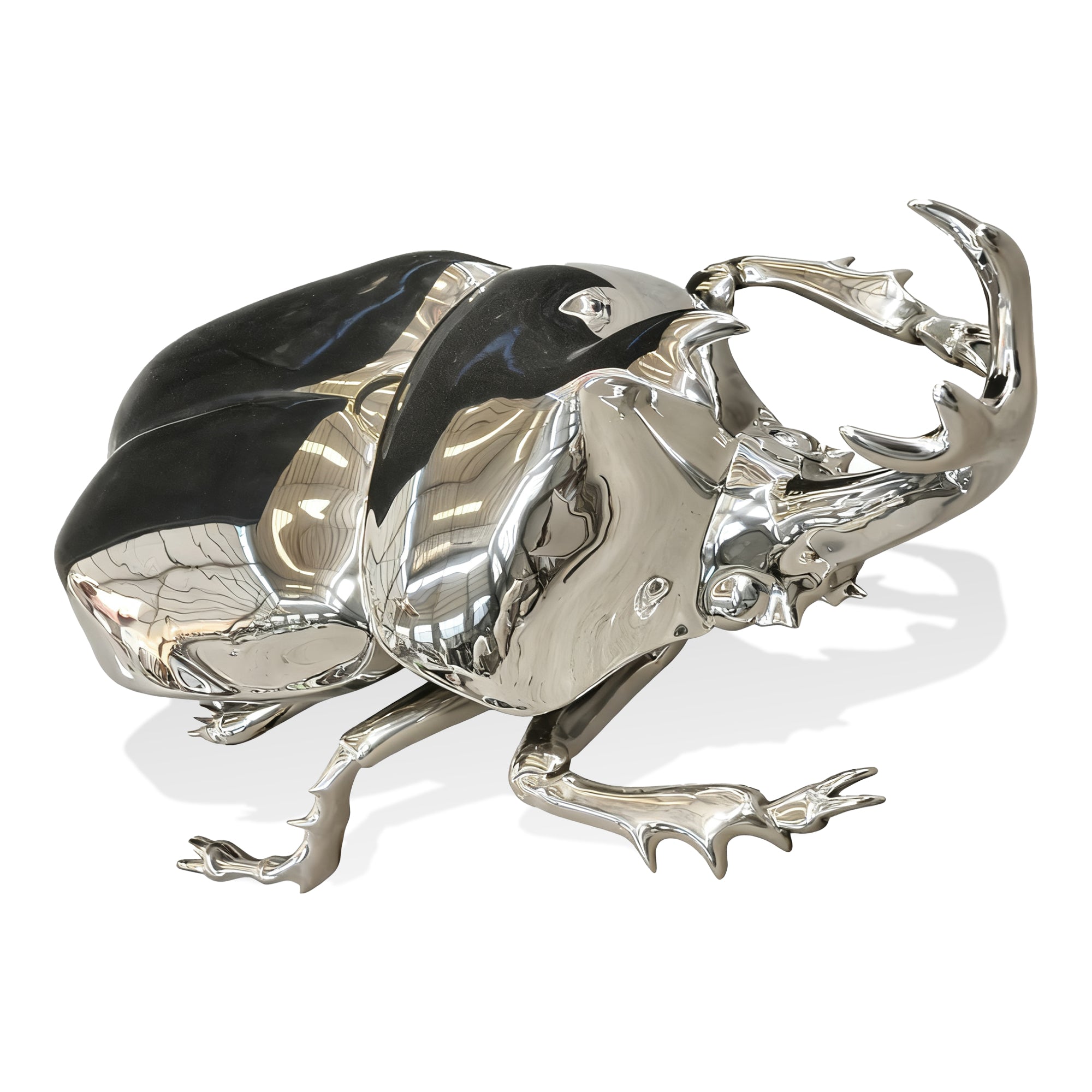 Silver and black decorative piece resembling a beetle on a white background