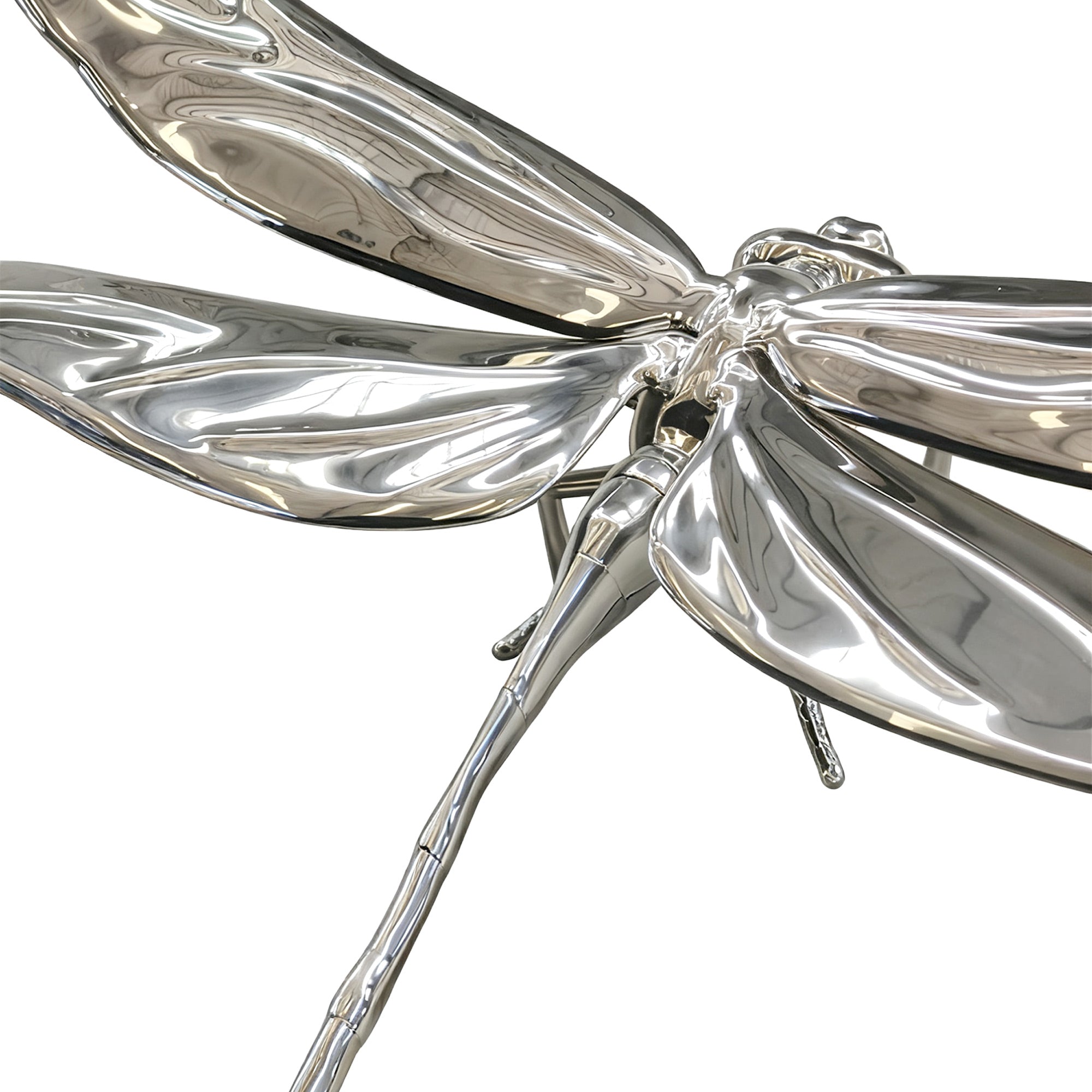 Silver dragonfly-shaped object on a white background