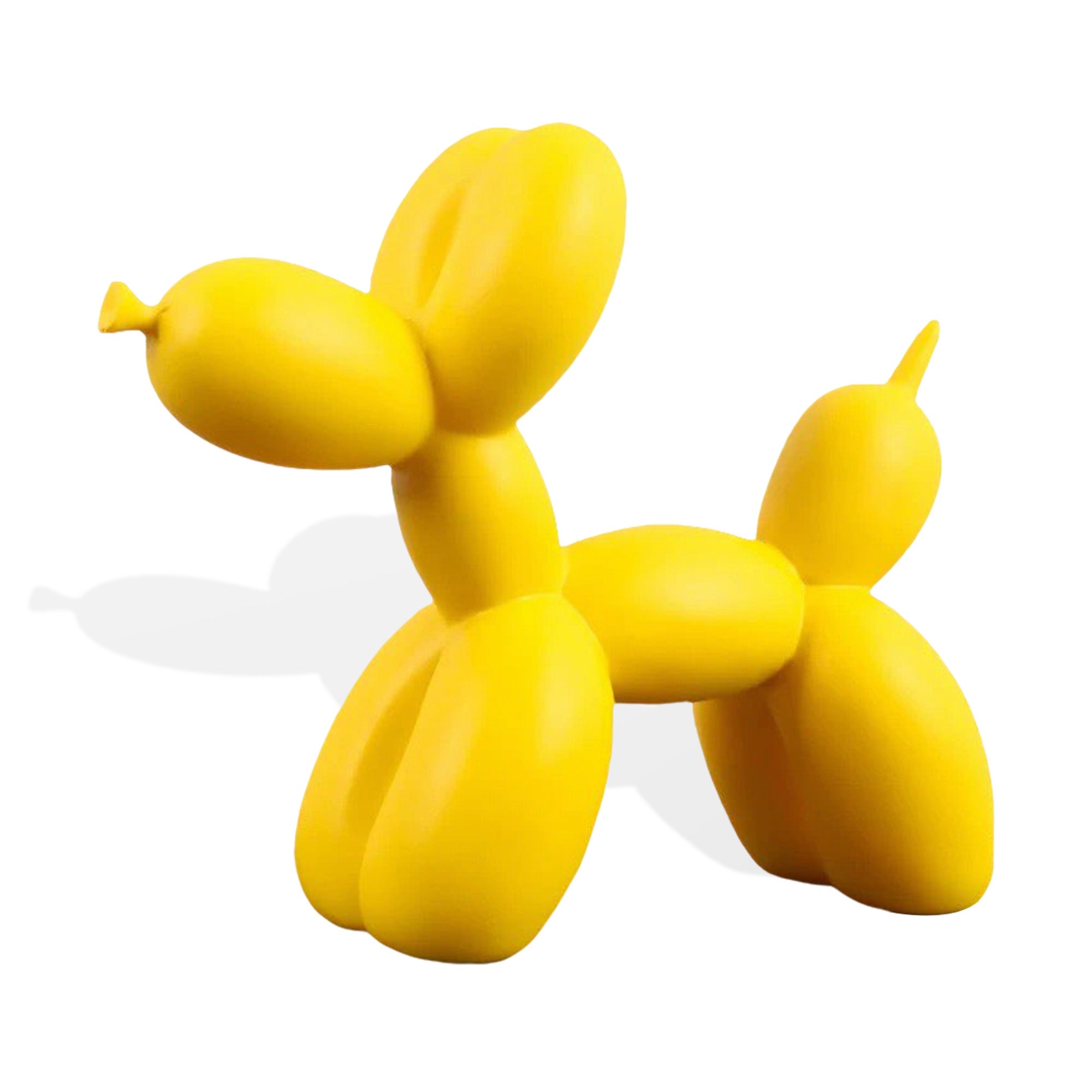Yellow balloon dog sculpture on a white background