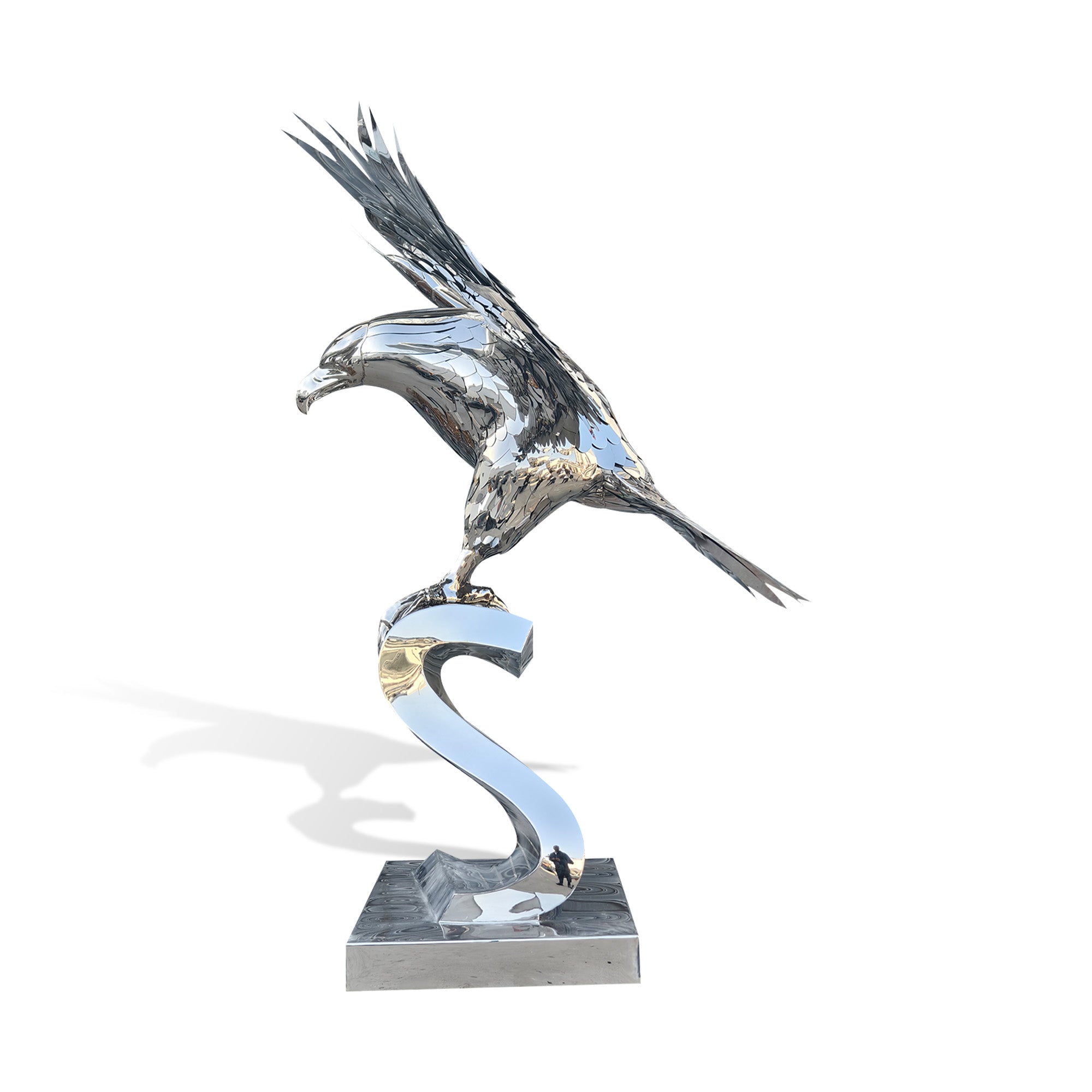 Side view of stainless steel eagle sculpture standing on a polished scroll base, with mirror finish, extended wings, detailed feathers, and patriotic American art design