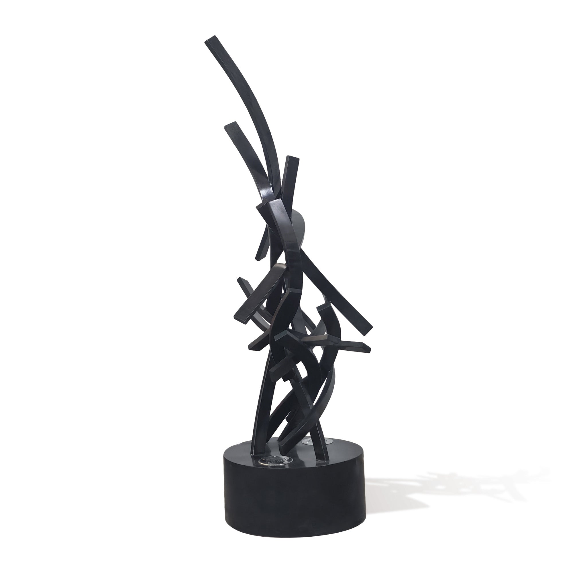 Angled view of illuminated abstract black stainless steel LED sculpture, modern light art statement piece on circular base.