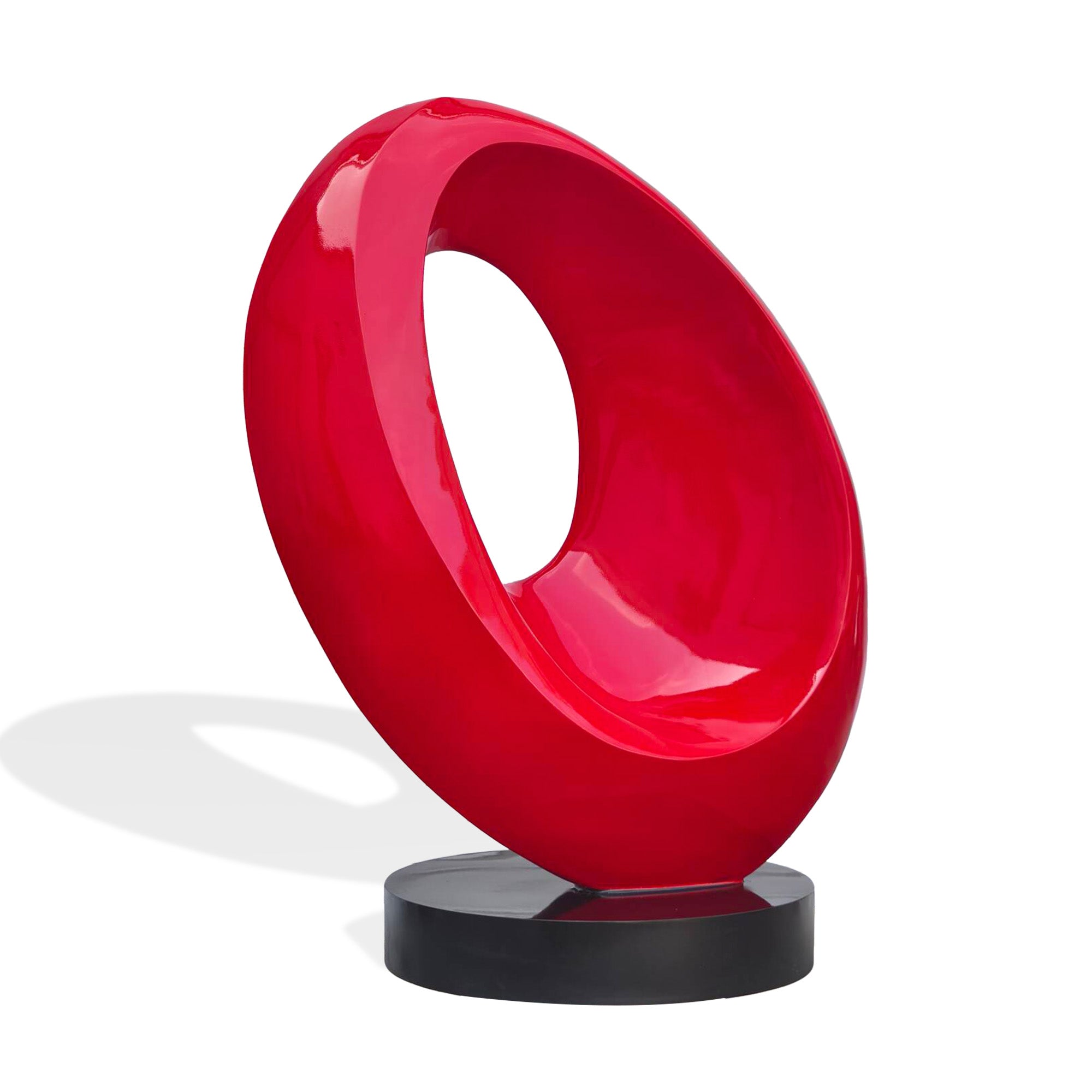 Angled view of glossy red stainless steel abstract ring sculpture, sculptural hollow form with smooth curves for luxury interiors and outdoor display.