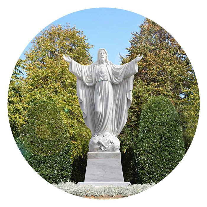 Sacred Heart Of Jesus Statues of a religious figure with outstretched arms in a park setting
