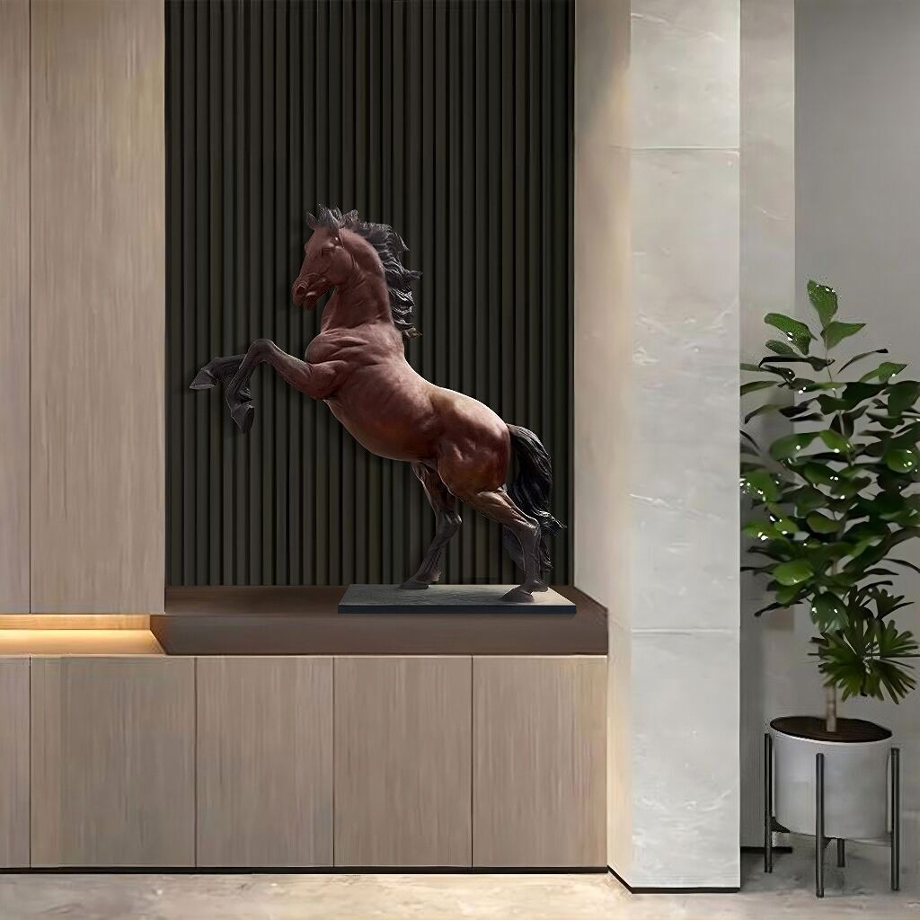 A polished bronze prancing horse sculpture on a pedestal, showcased in a modern, elegant interior