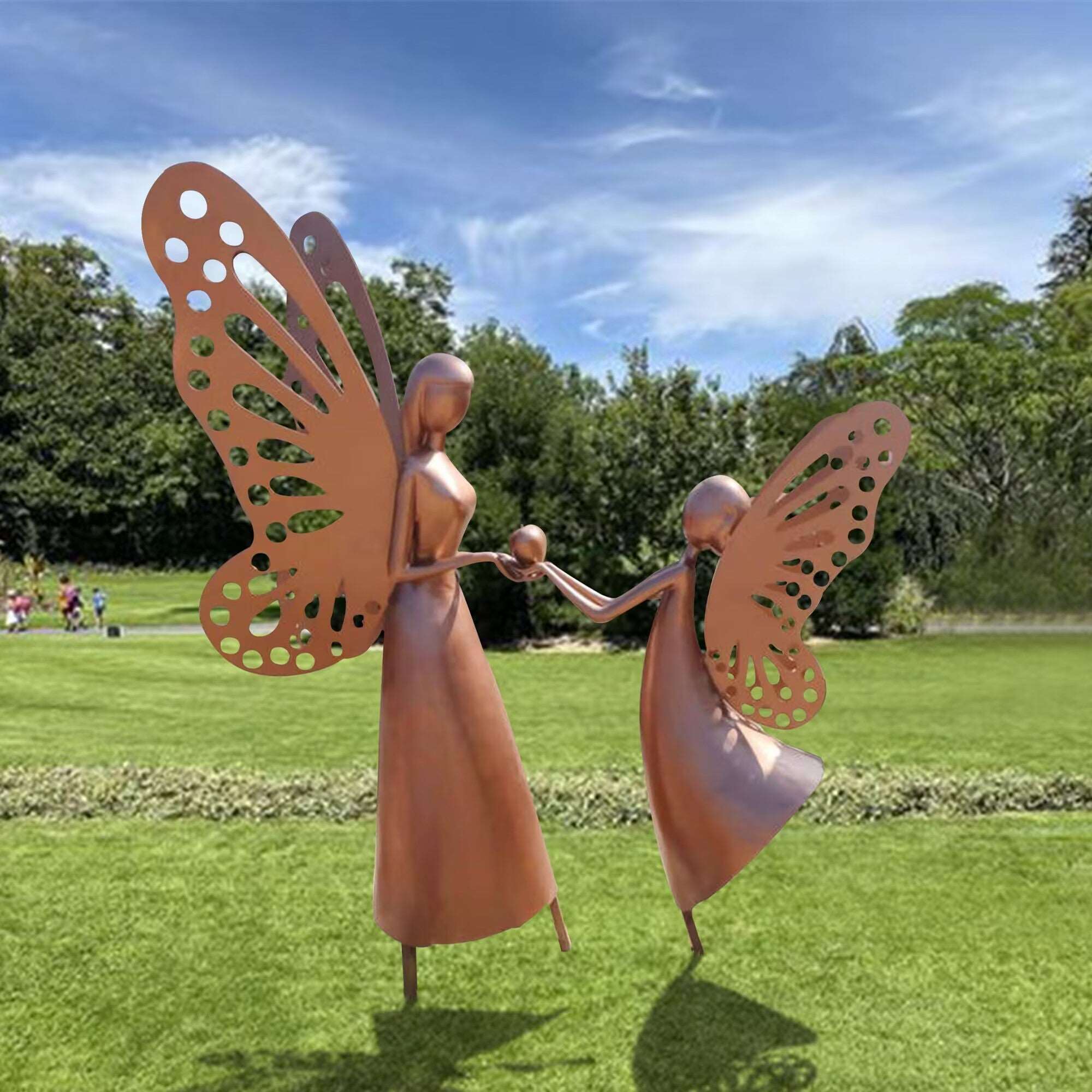 Copper sculpture of a mother and child with butterfly wings, standing together in a garden, symbolizing love and connection