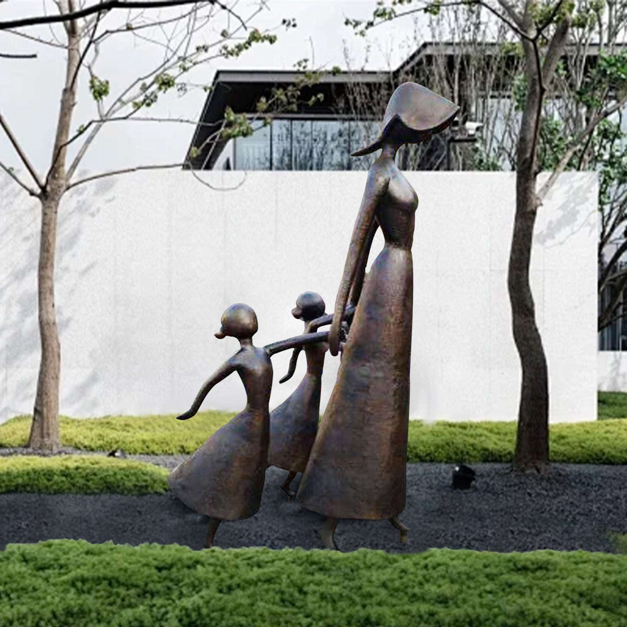 Bronze sculpture of a mother walking hand-in-hand with her two children, set in an outdoor garden