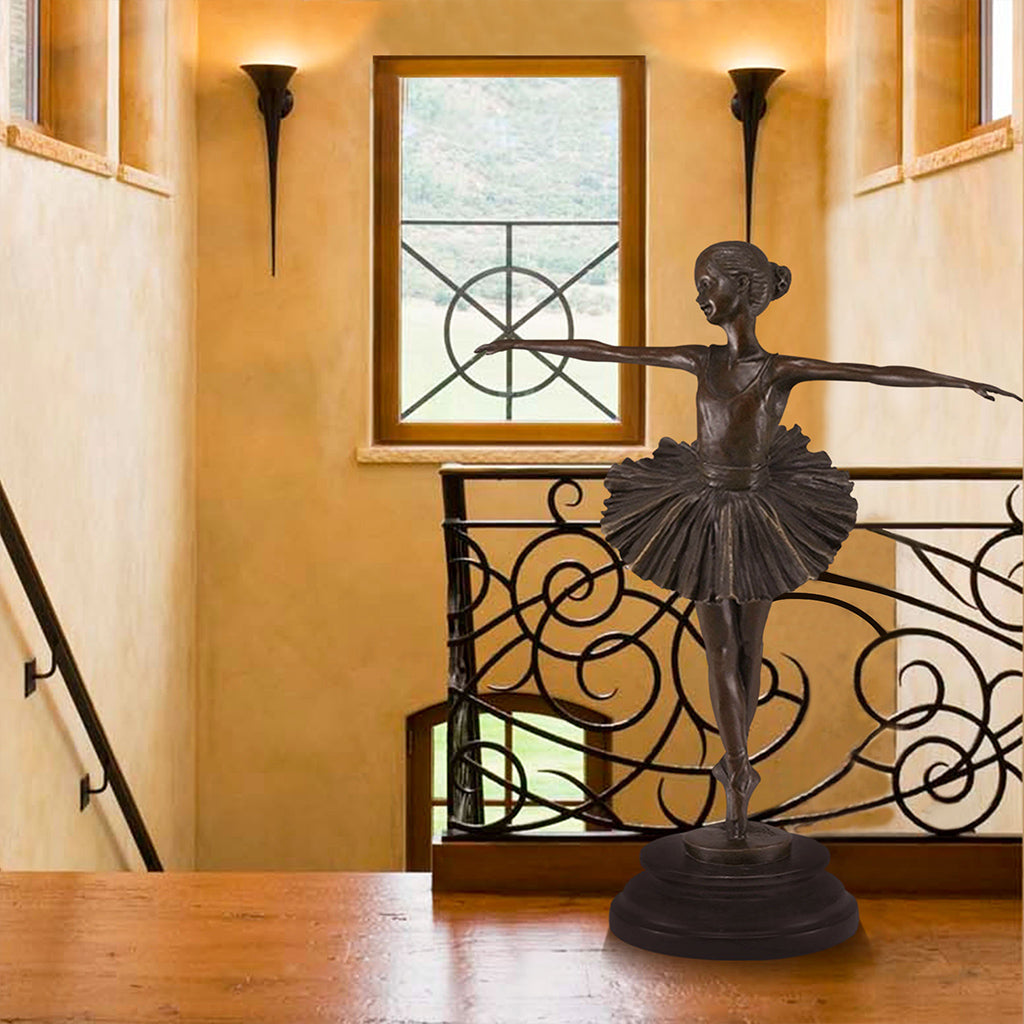 Bronze sculpture of a young ballerina in a graceful pose, displayed in a sophisticated interior setting