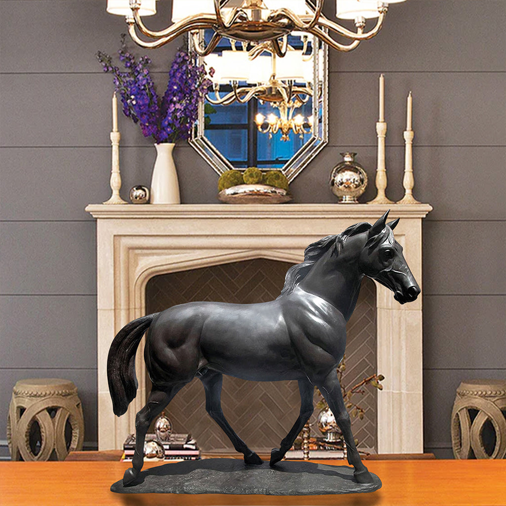 Bronze sculpture of a black stallion in a proud stance, displayed on a table in a refined interior setting