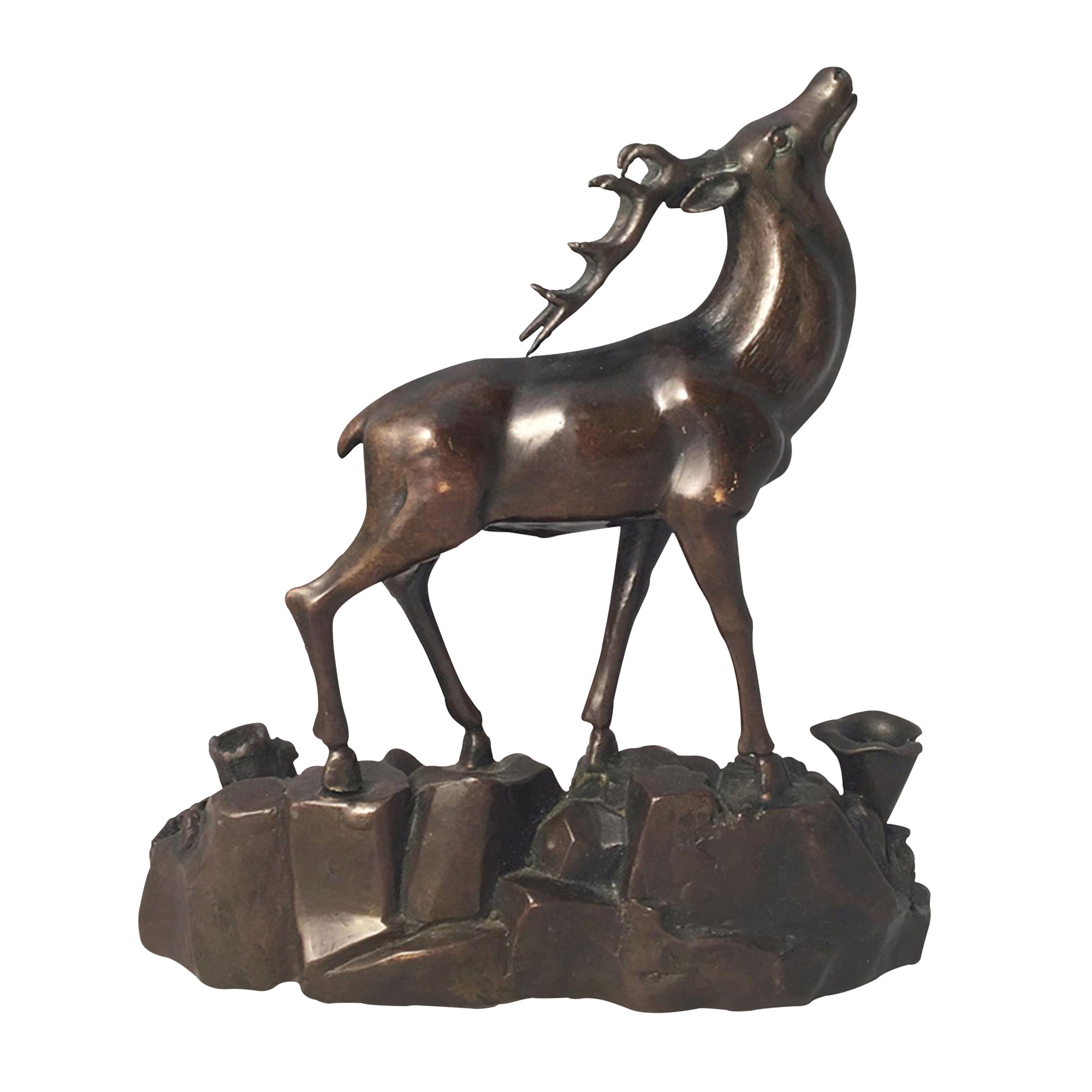 Bronze sculpture of a majestic stag standing on rocky terrain
