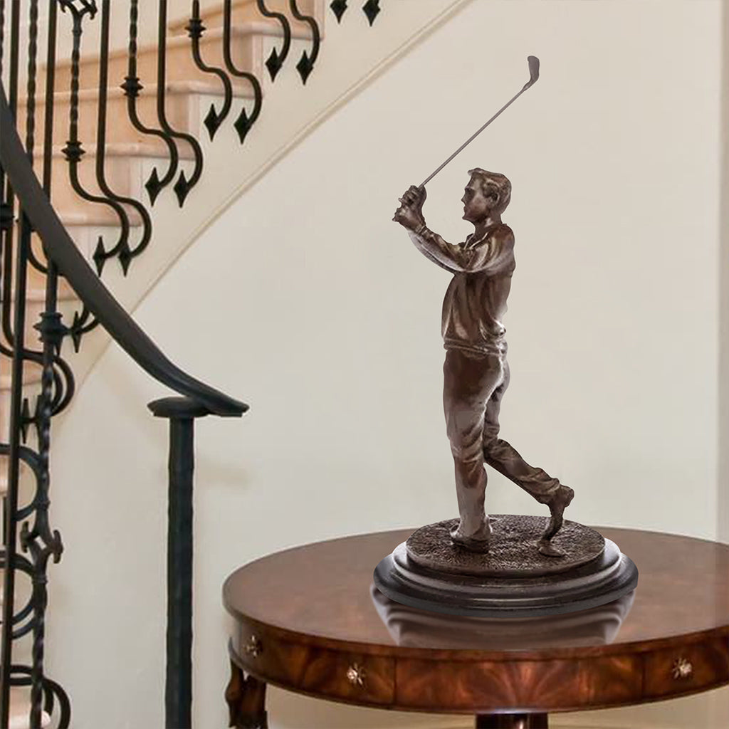 Bronze sculpture of a golfer mid-swing, displayed on a table in a refined interior setting