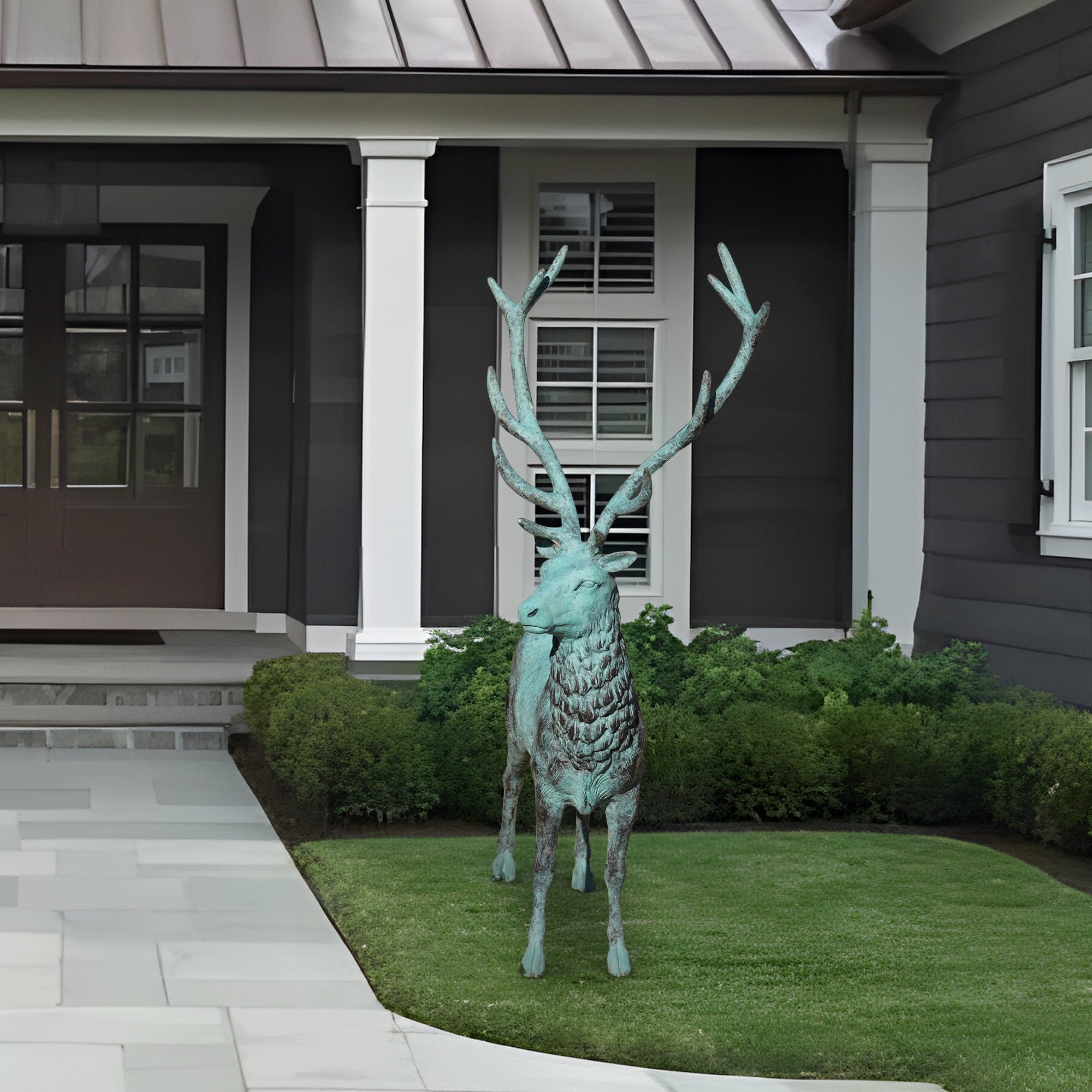 Decorative bronze deer sculpture in front of a house