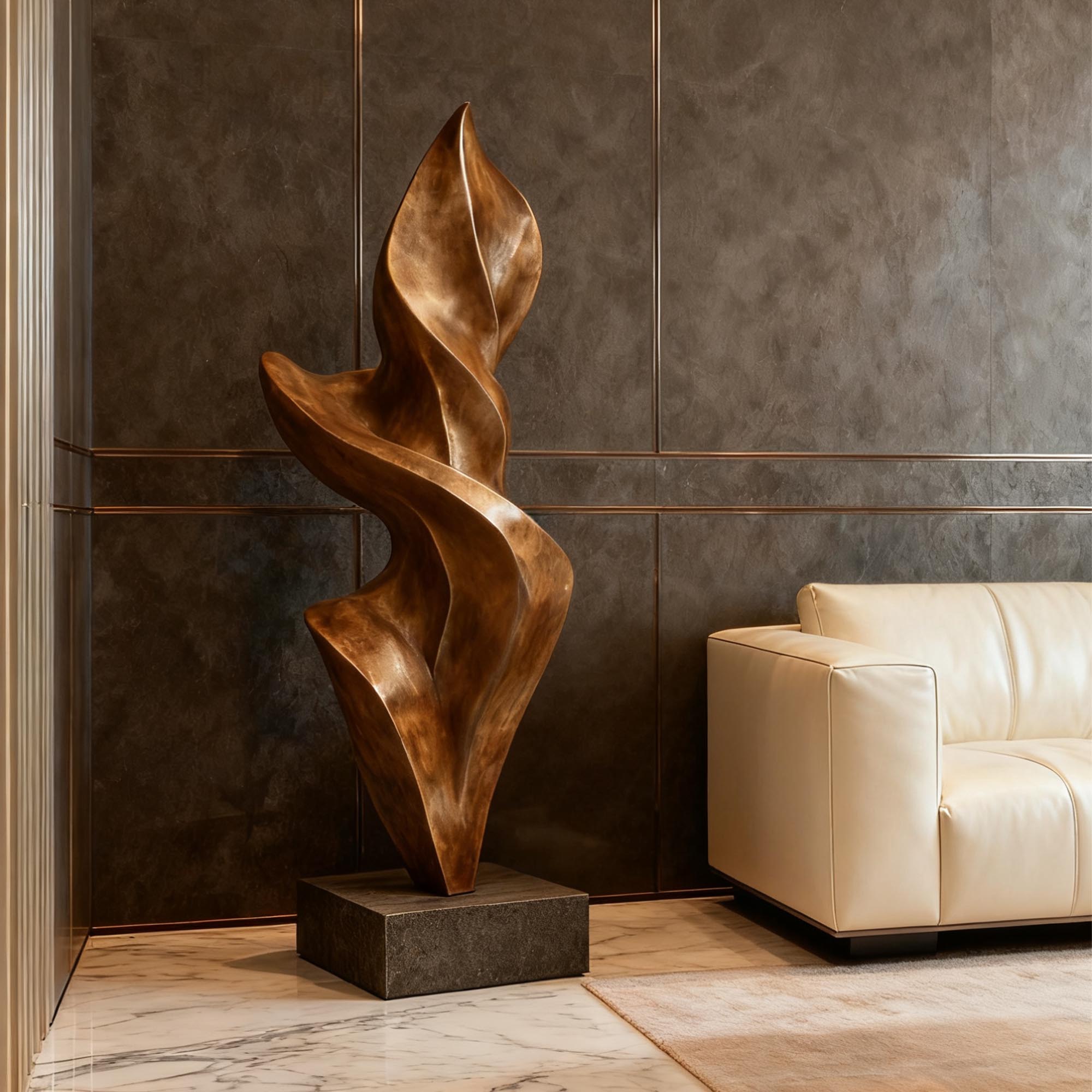 Abstract Bronze sculpture in a modern interior setting with a beige sofa and marble floor.