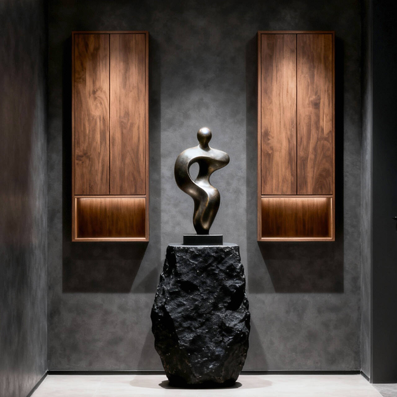 Bronze sculpture on a black rock pedestal against a dark wall with wooden panels